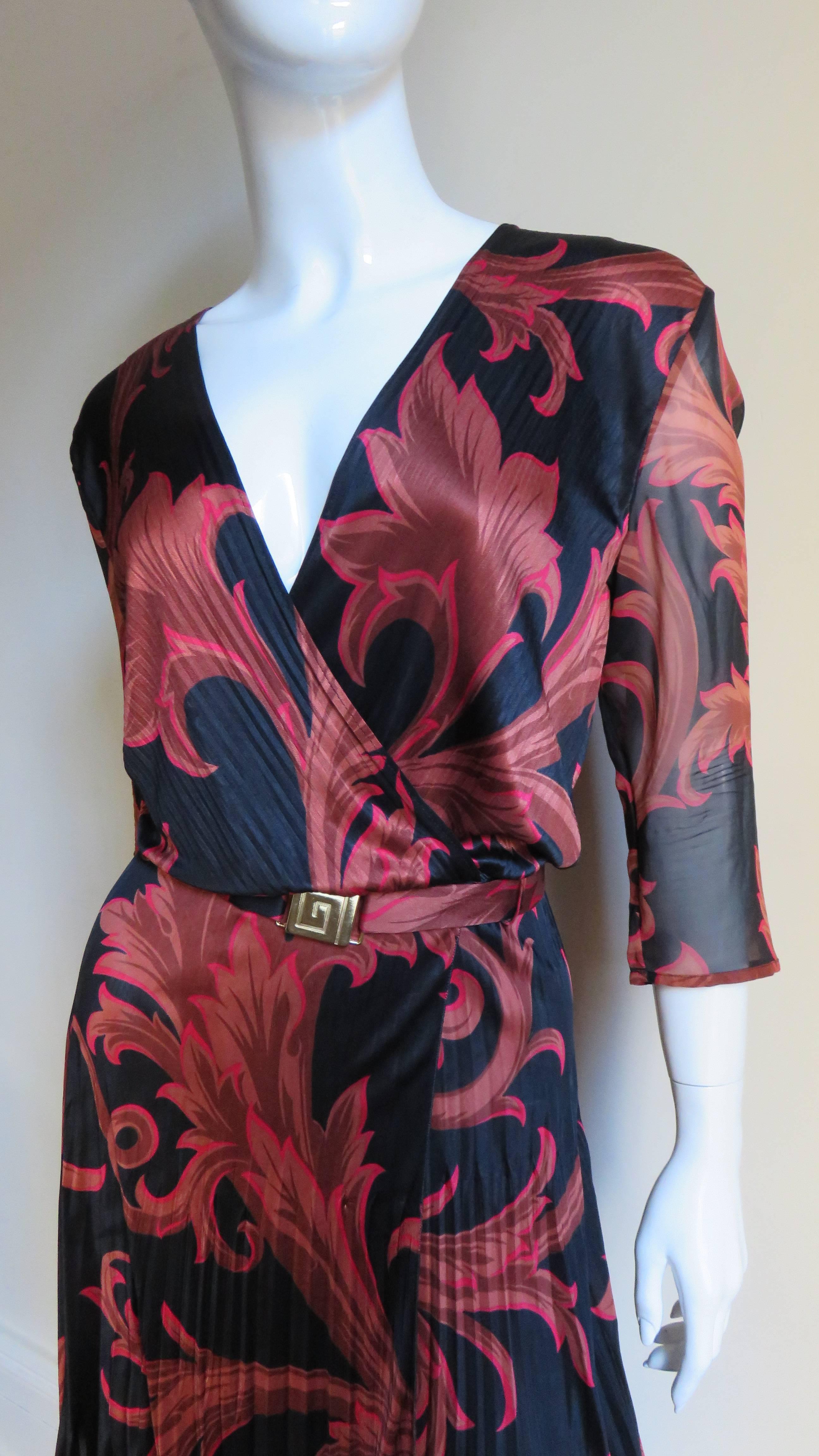 A great silk knit dress from Gainni Versace Couture in one of his infamous baroque prints of scrolls and abstract patterns in shades of tan outlined in red on a black background.  The body of the dress consists of a fine silk with a small linear