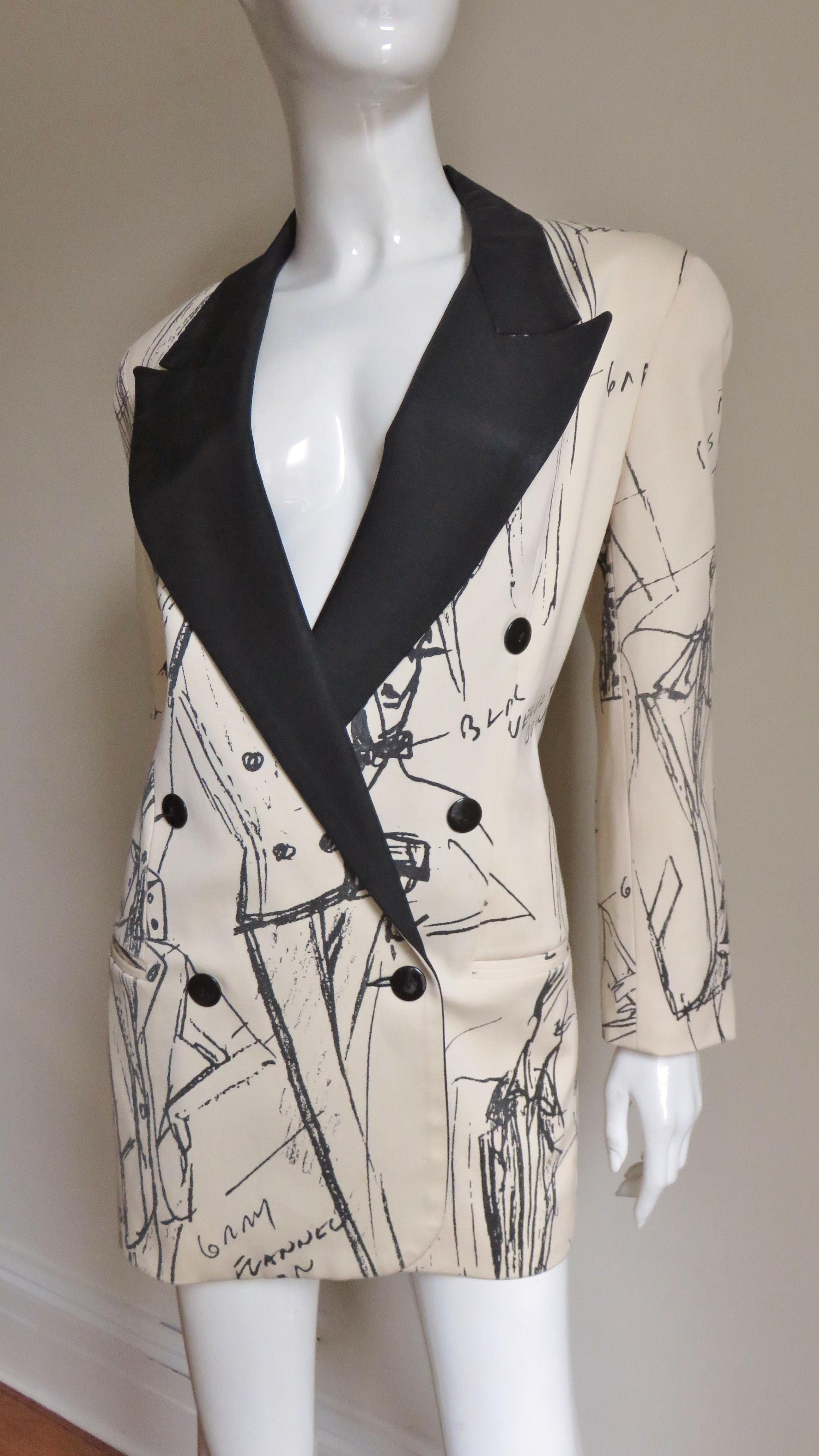 A unique off white wool jacket from Randolf Duke. It is double breasted with a black twill notched collar, hip welt pockets and long sleeves. Black buttons are on the cuffs and the jacket front. It has a unique pattern of fashion designer model