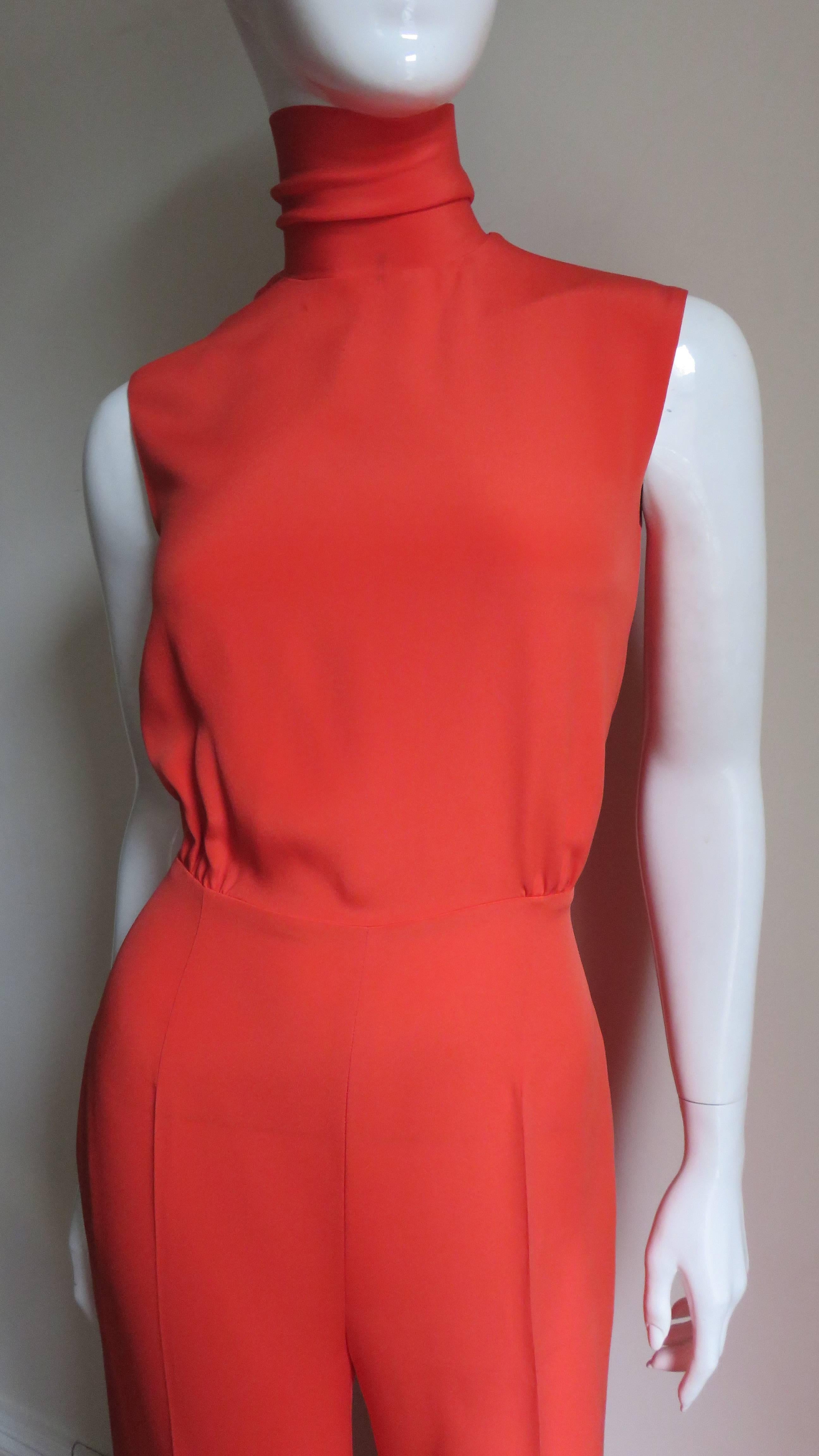 A very elegant orange silk jumpsuit from Celine.  It is sleeveless with a tie at the neck which can be worn a variety of ways.  The bodice slightly gathers at the waist and the wide leg pants have side seam pockets at the hips which are lined in the