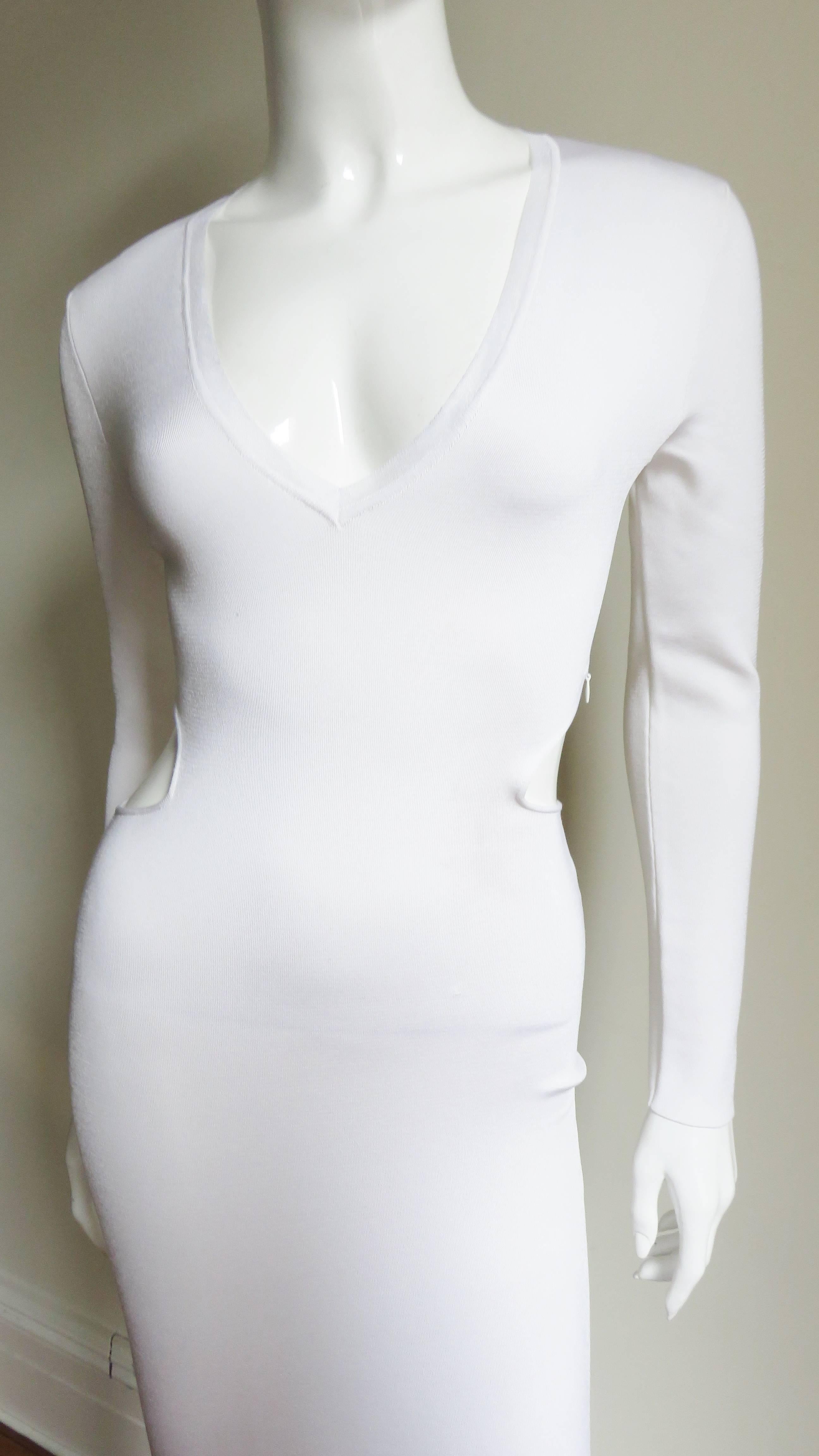 A fabulous white bandage knit dress from Tom Ford.  It  is fitted with long sleeves, a plunging neckline and a cutouts that extend from the side to side exposing the back waist dress.  It is unlined and has a side bodice zipper.  There are 3 pulls