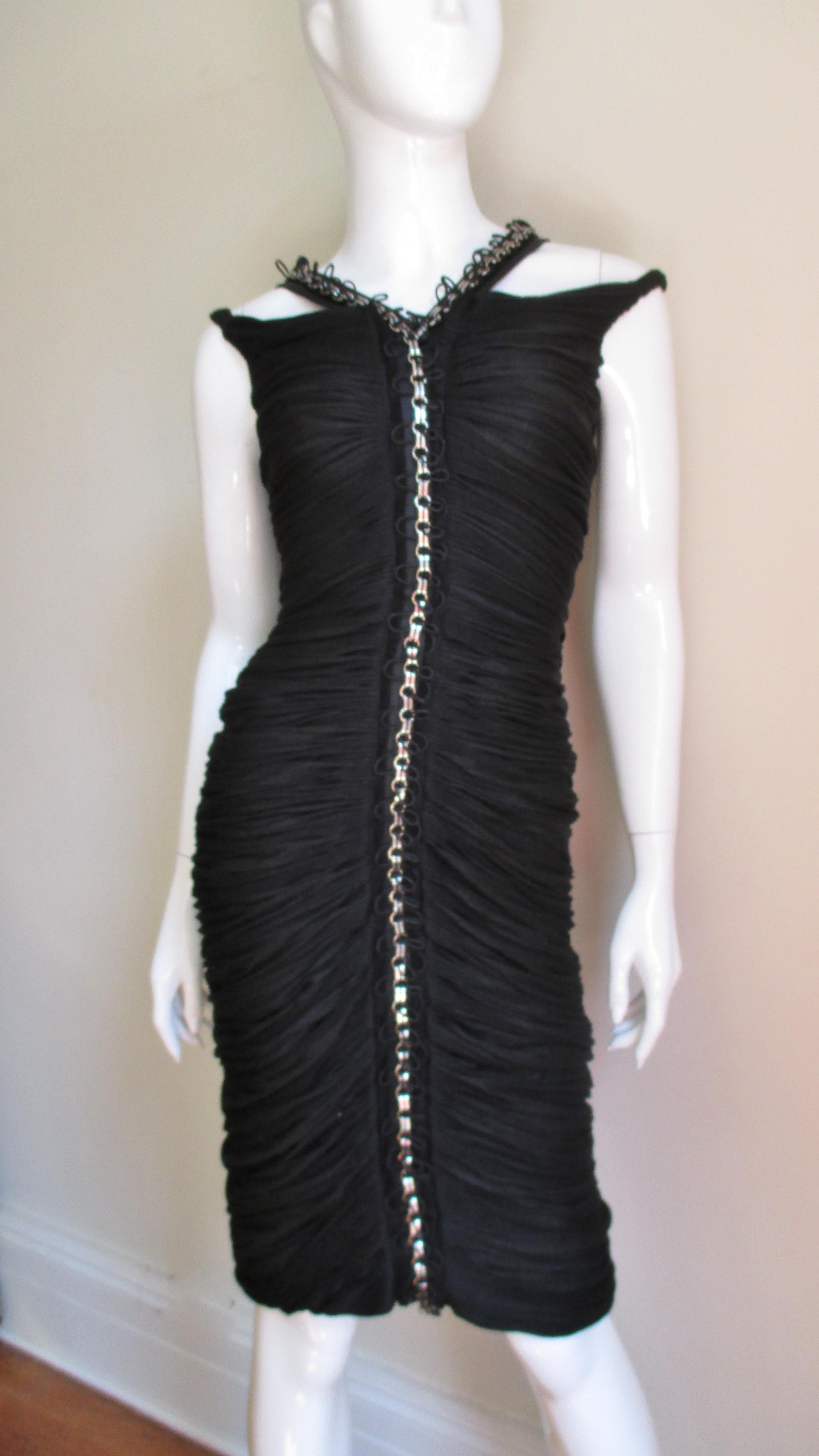 This dress is amazing.  Made of a rich black delicate light weight silk blend knit ruched horizontally across the dresses entire length front and back.  It is fitted and where the ruching meets in the center front and back it is accented with silk