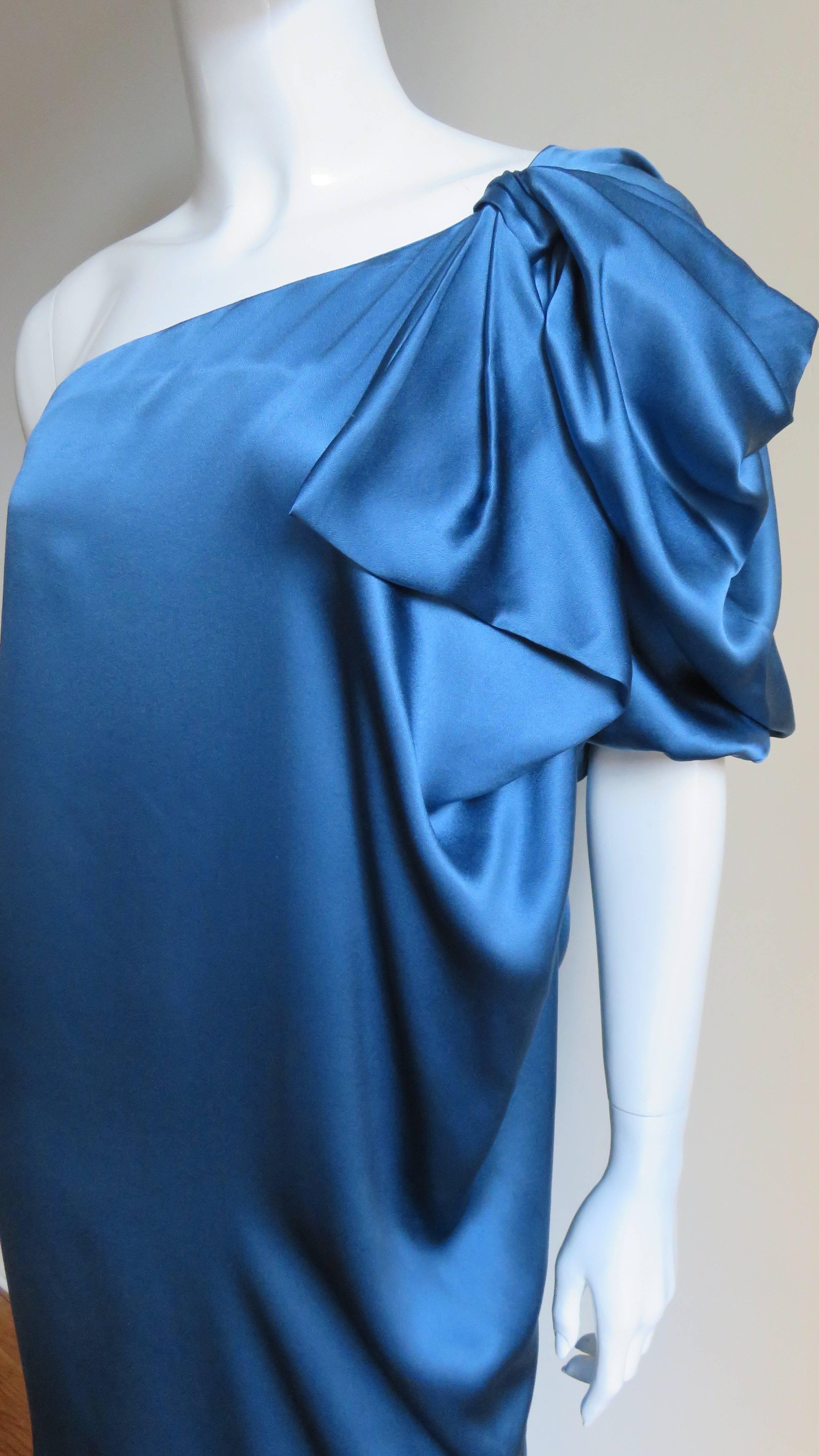 A beautiful Azure blue silk dress from Stella McCartney.  It has a puff sleeve cut in one with the dress with shirred elastic at the end and draping at the shoulder.  The dress is sack style narrowing at the hemline.  It is unlined and slips on over