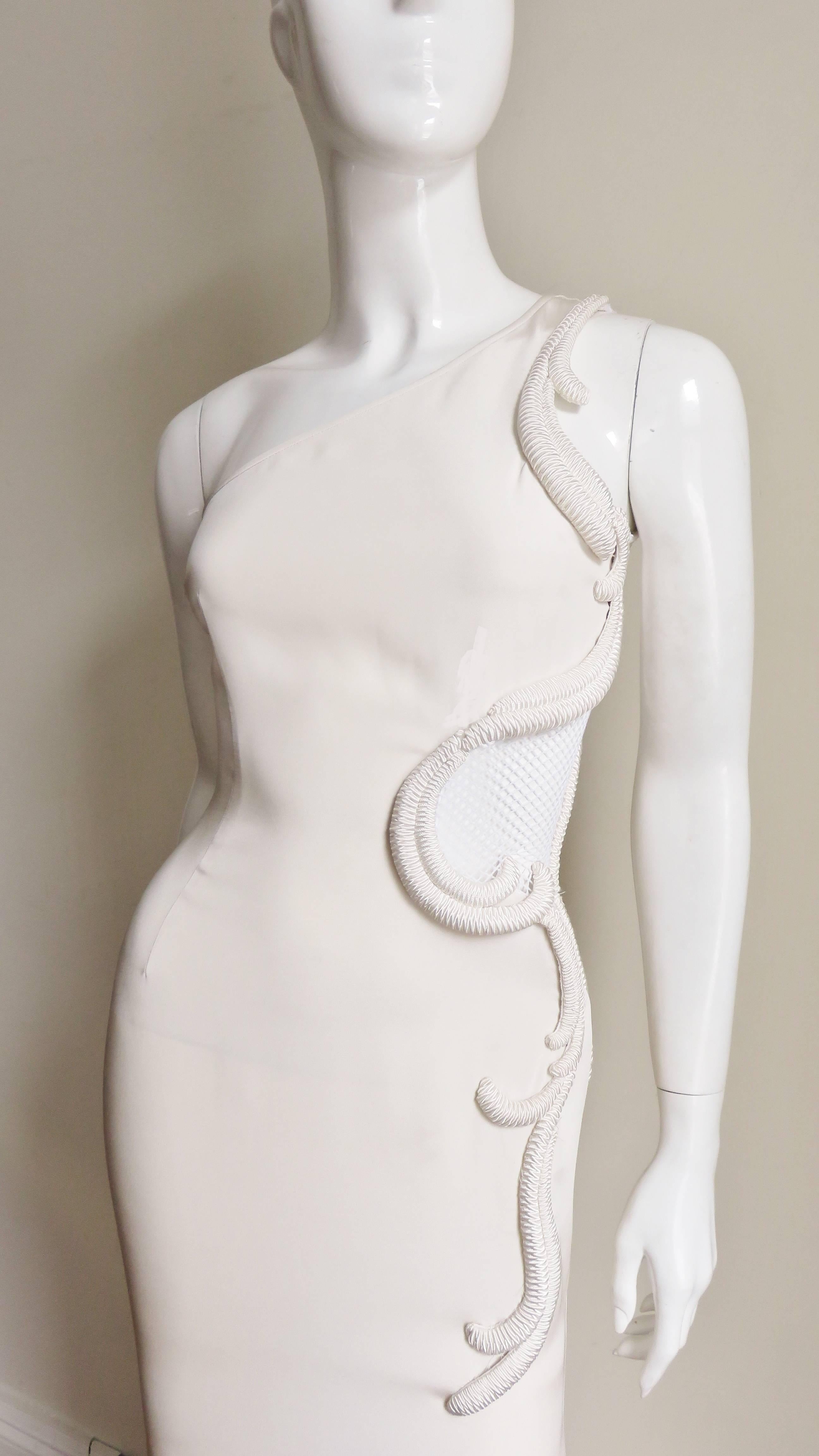 This is absolutely stunning- it is a medium weight off white silk one shoulder gown by Stella McCartney.  The one shoulder and armhole down the side through to the hip has a net covered cutout which is surrounded with  elaborate silk segmented