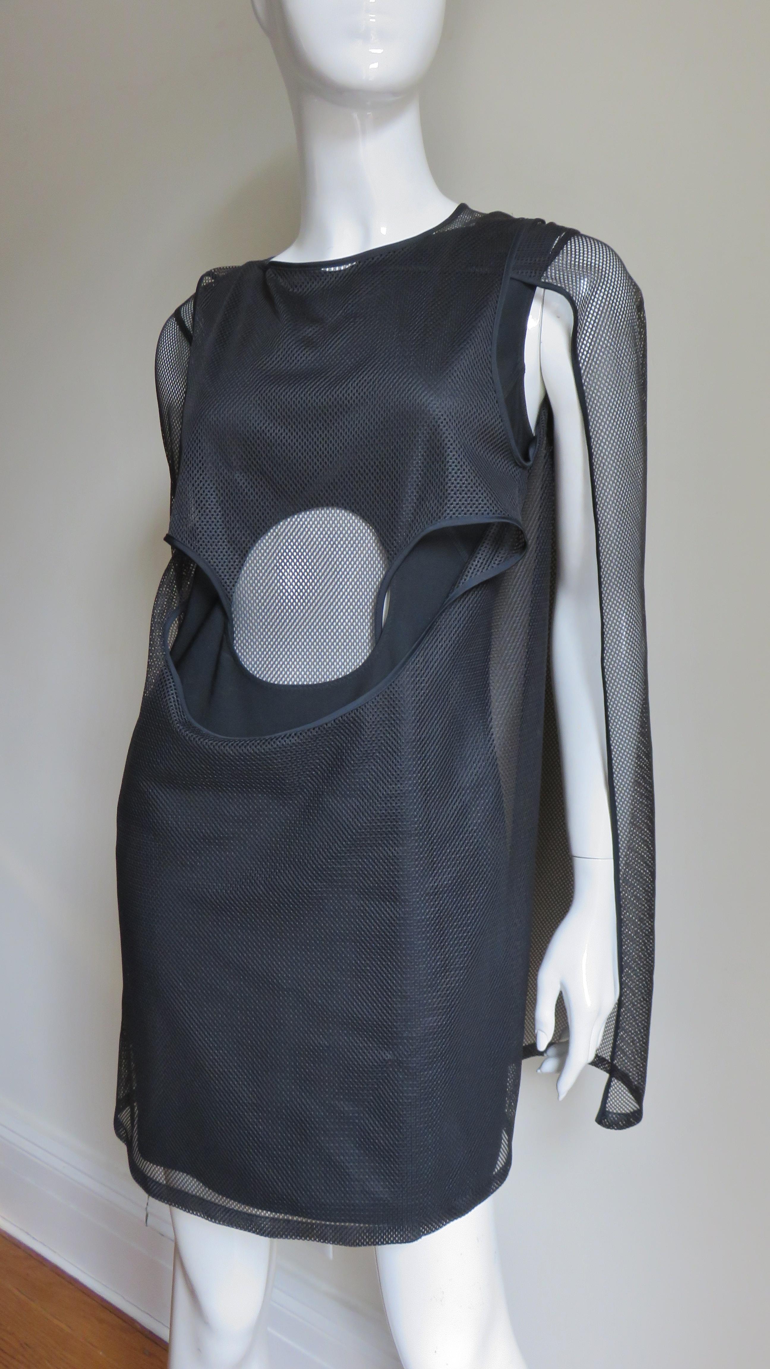 A great black stretch dress from Junya Watanabe for Comme des Garcons, CDG.  It is sleeveless with a cutout circle at the front waist and several layers of black net over top. It slips on over the head.
Fits sizes Small, Medium.  Marked size