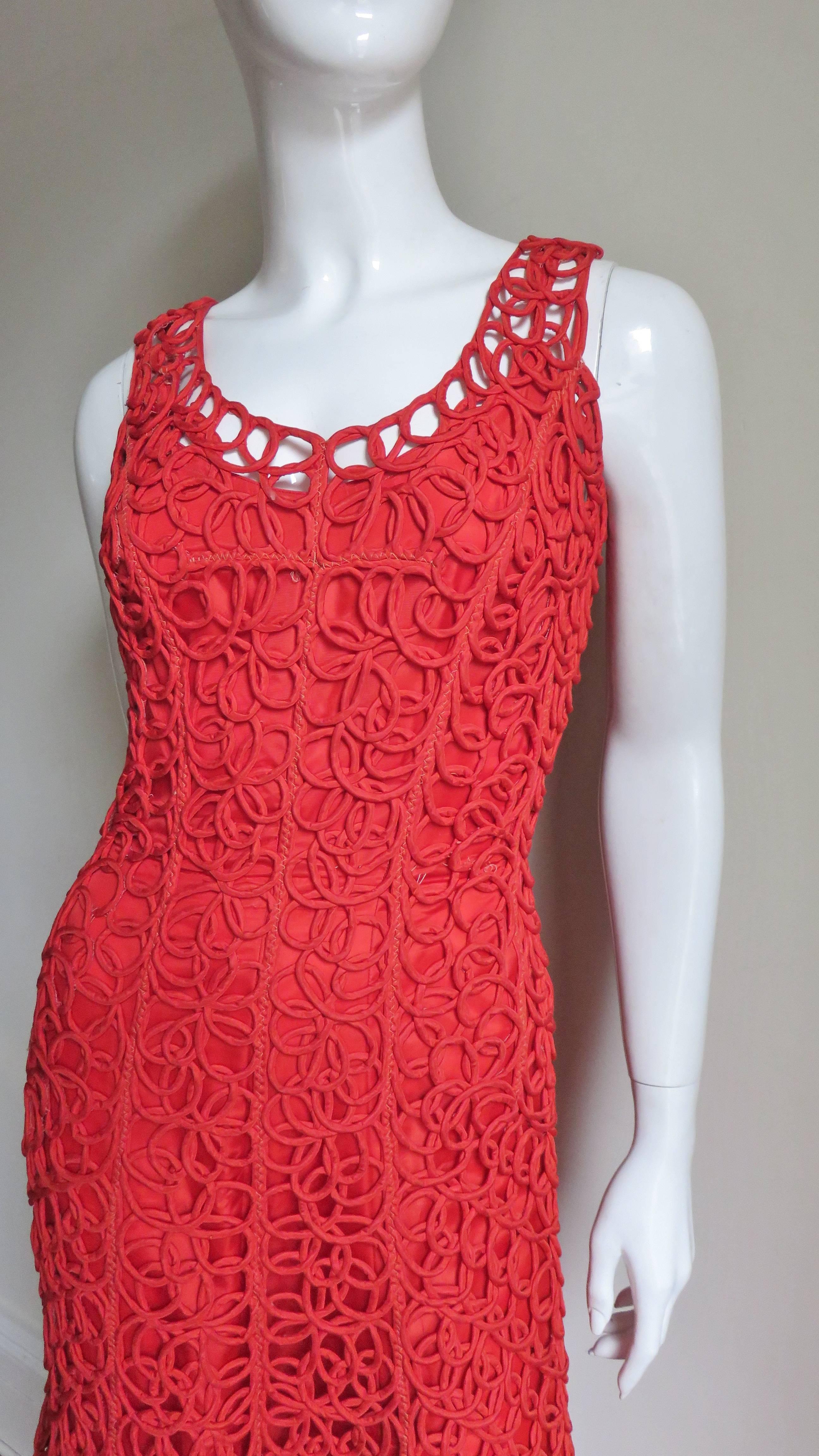 This is a fabulous, unique 1950s red dress comprised of yards and yards of piped fabric sewn in a circular coil pattern.  The dress is sleeveless with a scoop neck, semi fitted through to the hips then flaring towards the hemline.  It has a back red