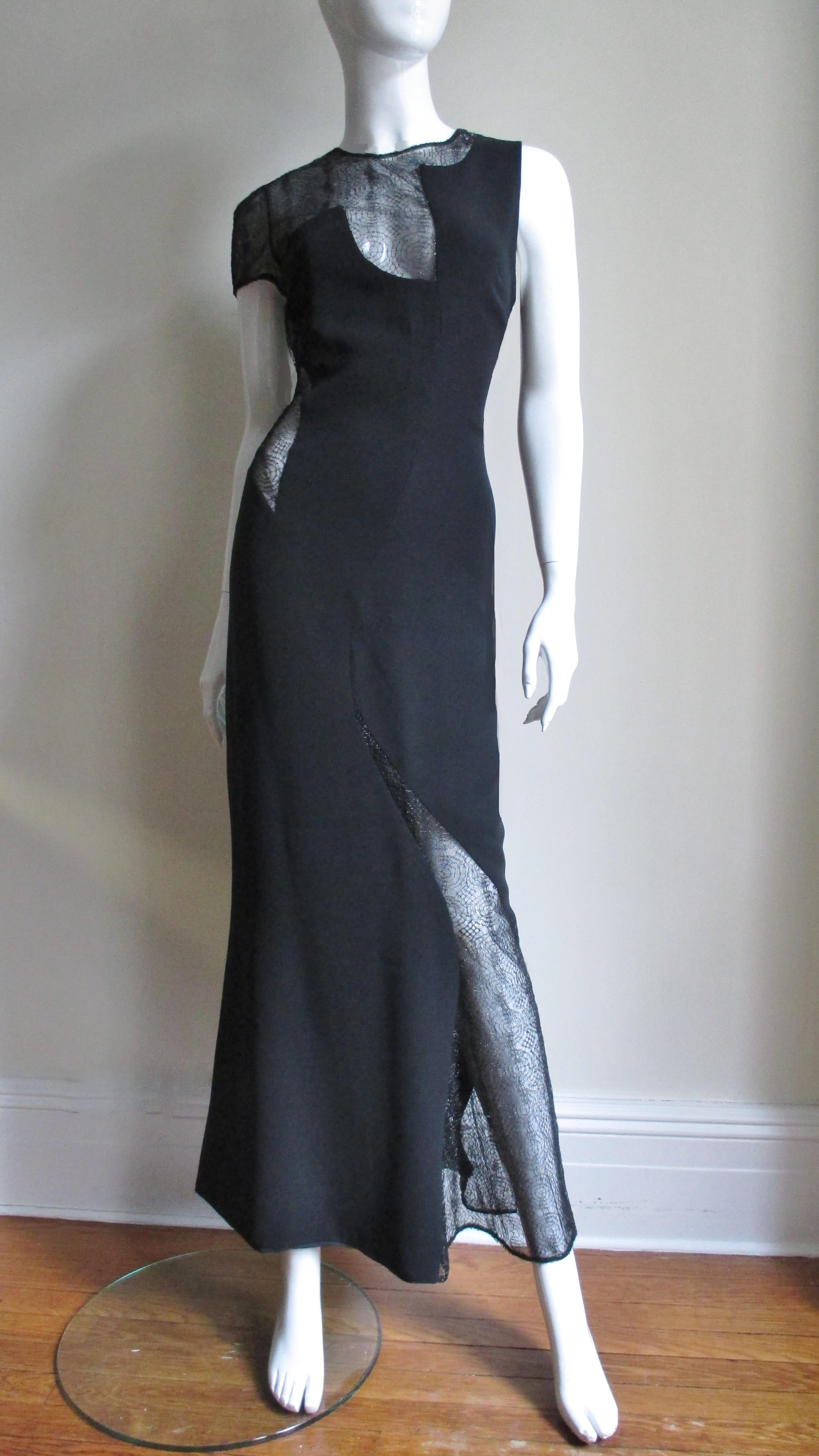 An amazing Gianni Versace Couture full length black silk dress.  it has a scoop back and one short sleeve.  It is asymmetrically cut with web pattern lace covered cut outs at side, leg, sleeve and decolletage. The dress skims the body through the