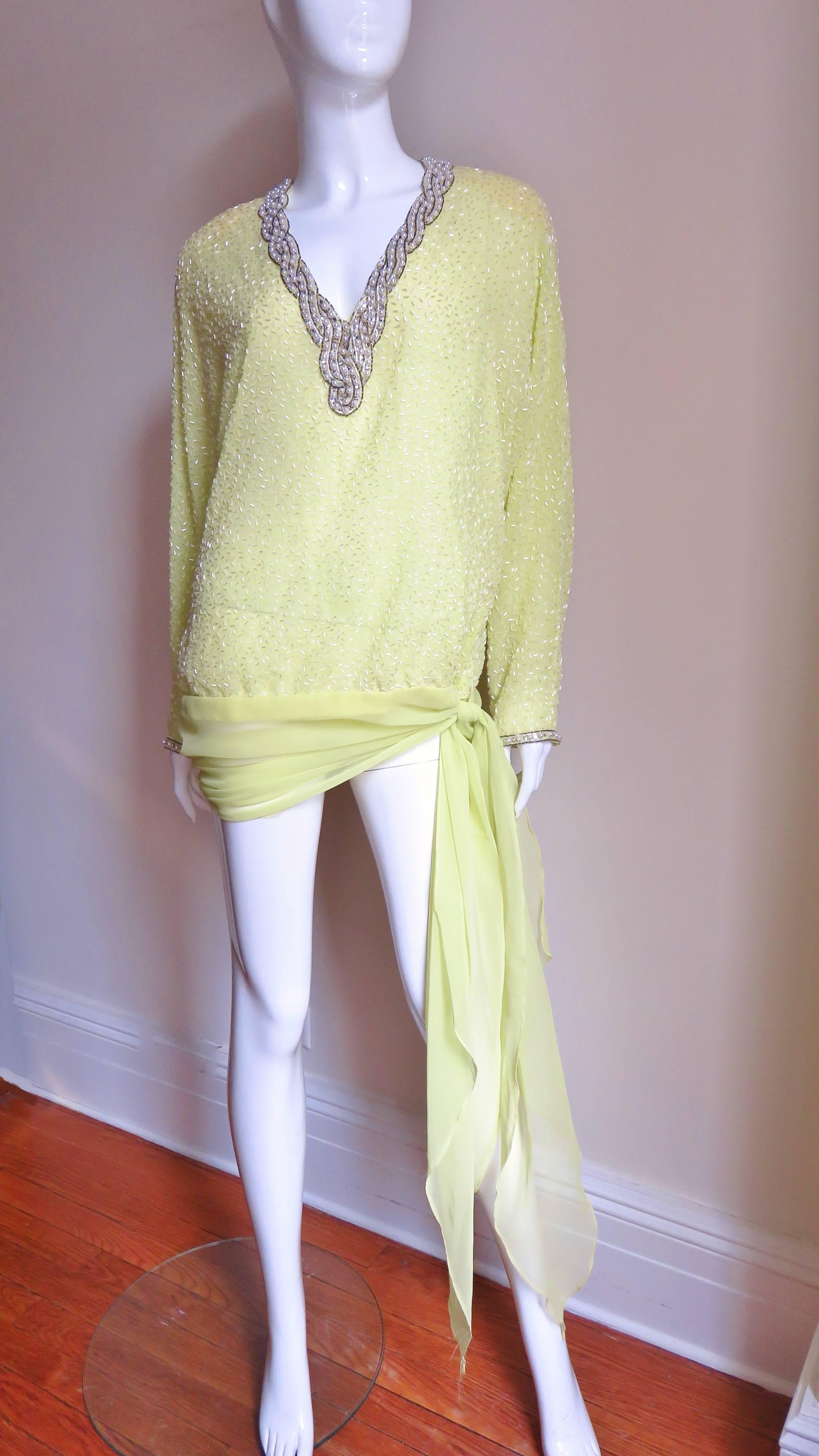 A pretty semi sheer lemon colored top by Royal Victoria in British Hong Kong from an era and part of the world know for bead work.  It has a deep V neckline, long dolman sleeves with zipper cuffs and a wide sheer swath of  sheer fabric gathering and