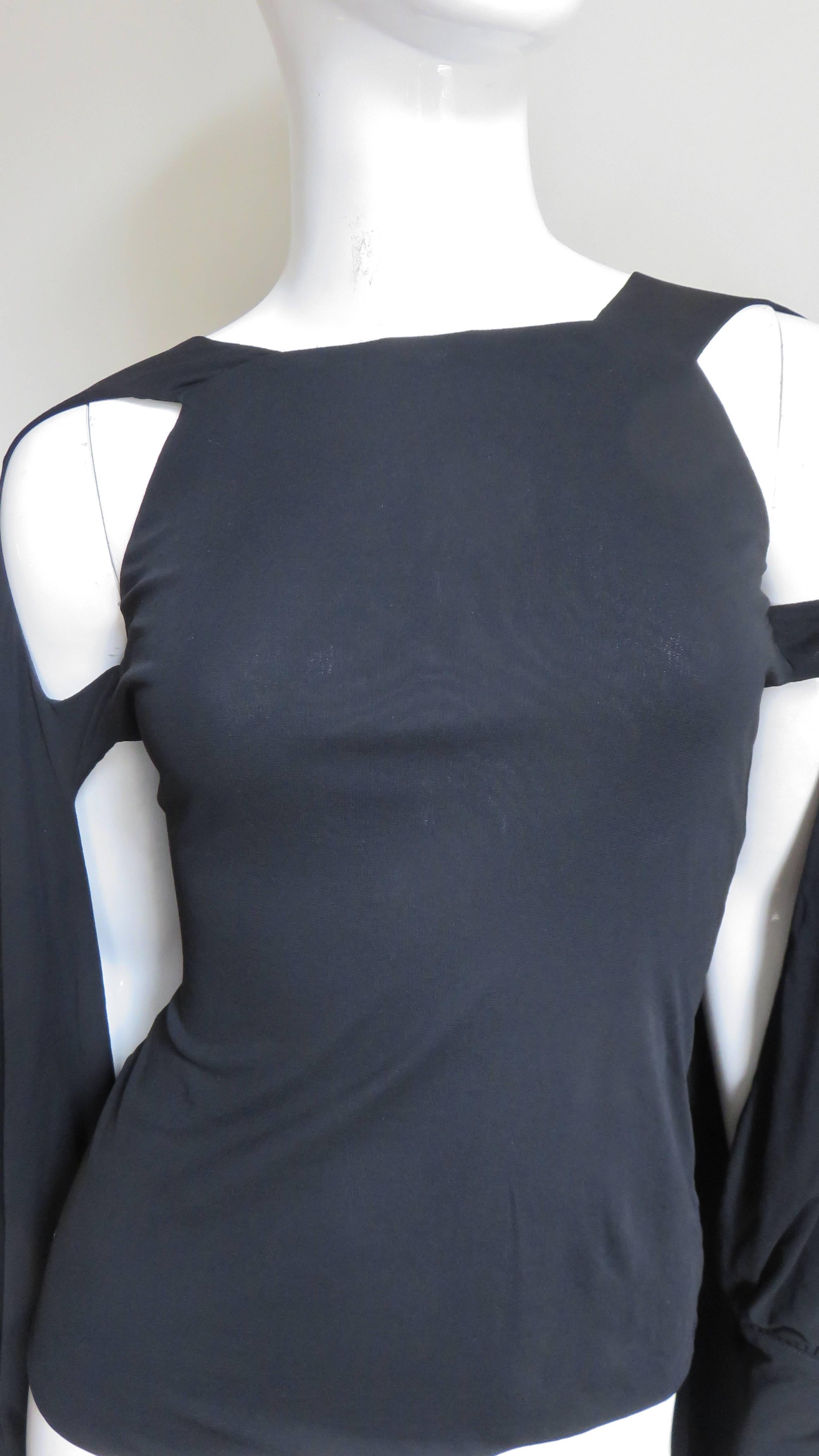 A fabulous black silk jersey top from Antonio Berardi.  It is a basic t-shirt with straps at and below the shoulders on the arms.  The straps drape into full back cape with 5 button cuffed sleeves revealing the front of the arms.  
Appears unworn