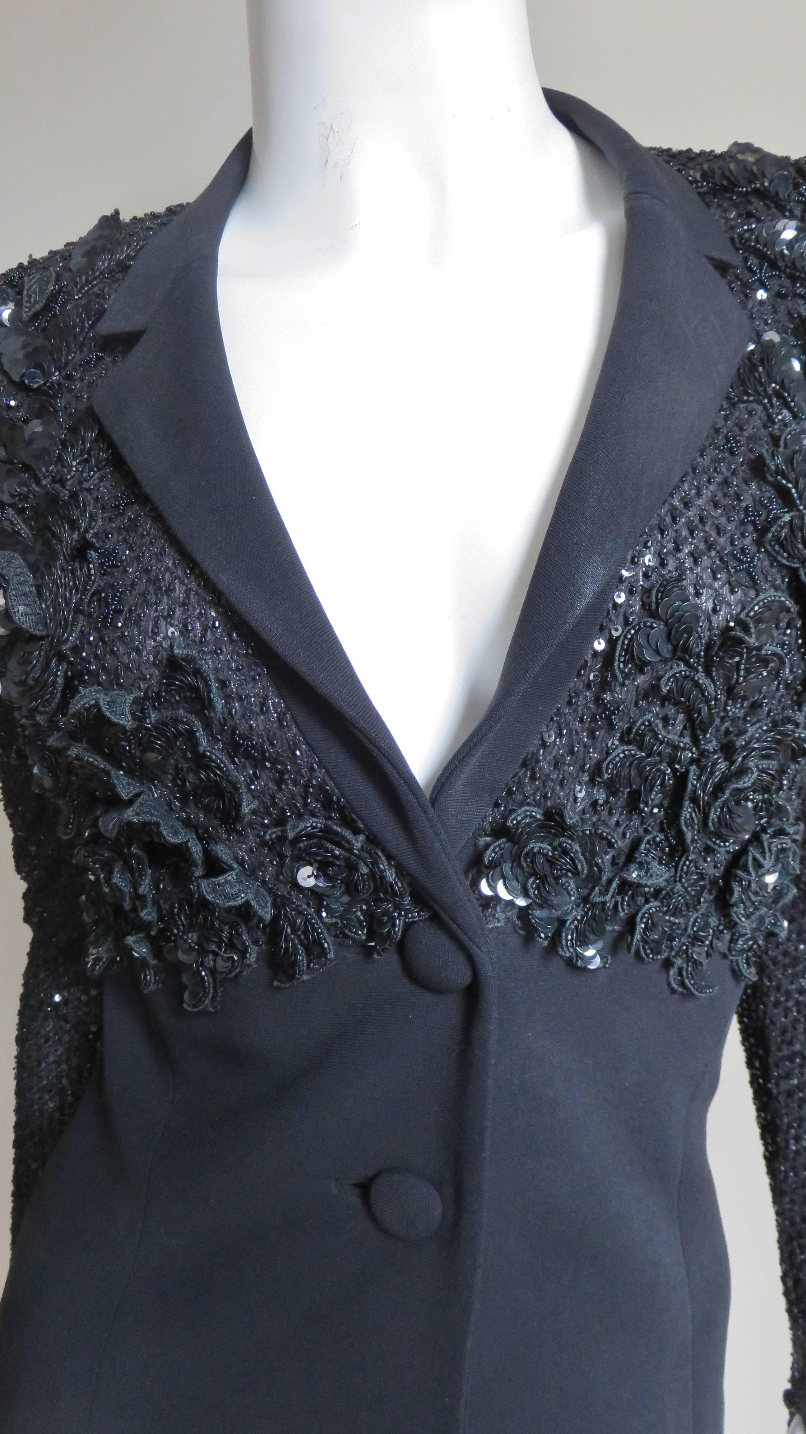 A great black silk jacket from Badgley Mischka.  With the exception of the small lapels the upper portion is an elaborate pattern of glass beads and sequins onto which flower appliques created out of the same are attached onto the jacket in the