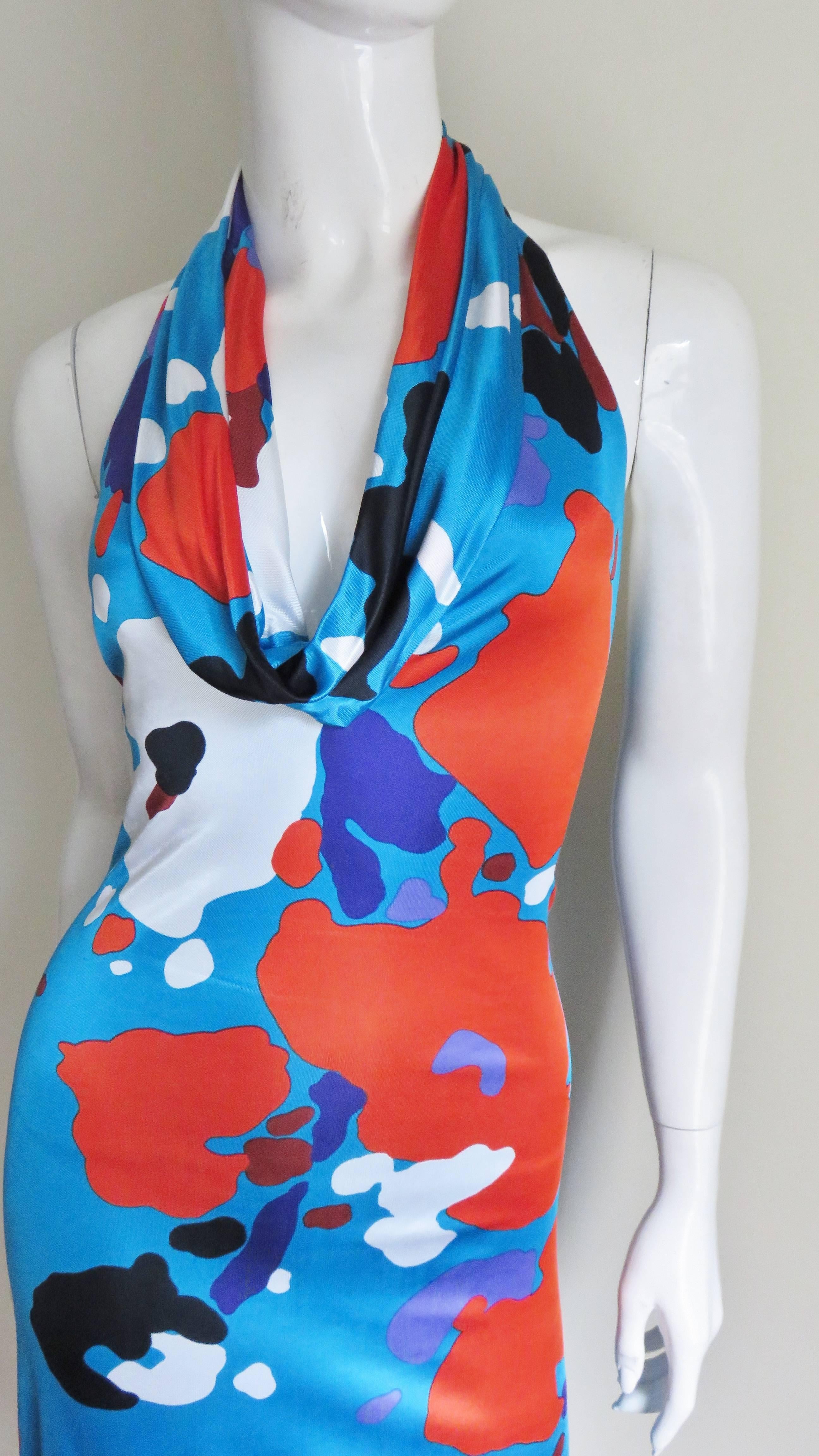 Brightly patterned fine silk knit dress from Gianni Versace Couture. The background color is bright cerulean blue with an abstract pattern of shapes in white, black, blue, red, burgundy and purple. The dress is halter style with the front falling in