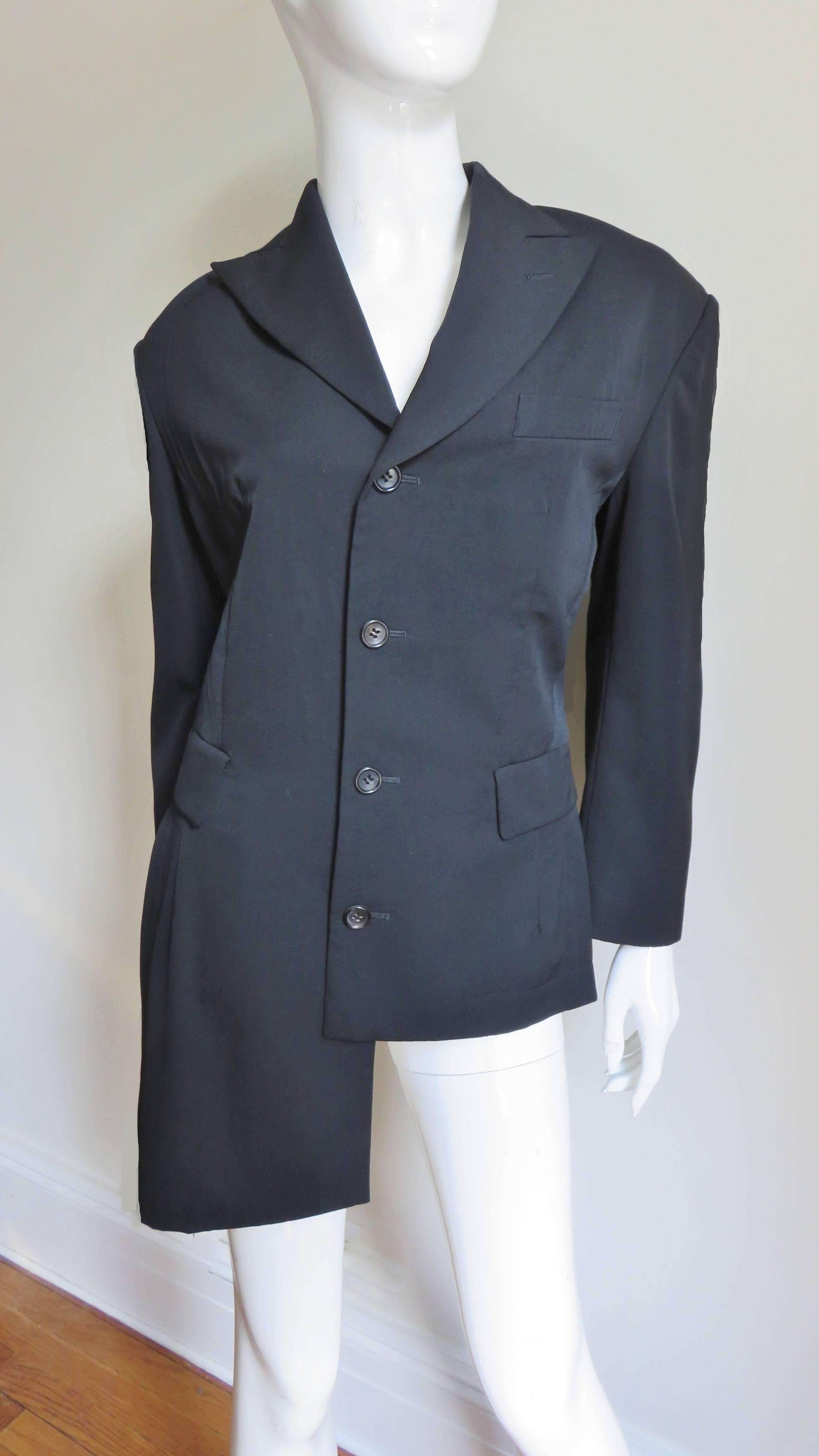 An incredible black light weight wool jacket from Comme des Garcons, CDG.  It is fitted at the waist with princess seams and has long sleeves, peak lapels and 2 flap welt pockets front pockets and 1 breast pocket.  It is stunning with the asymmetric