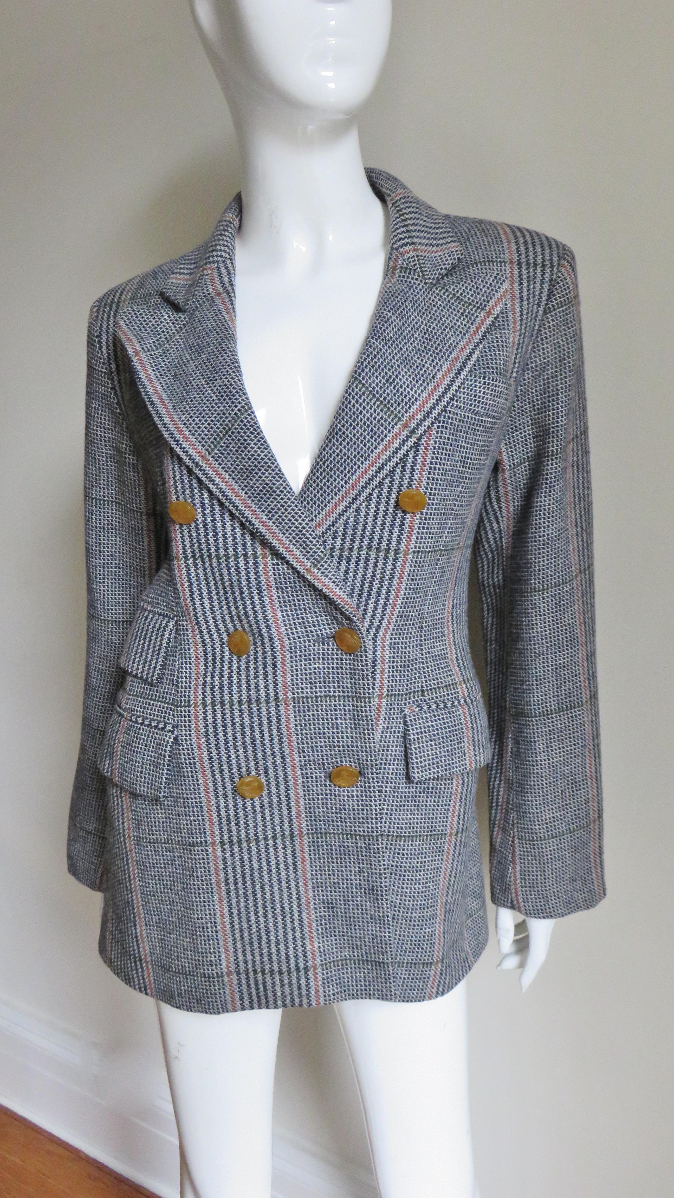 A great black, grey and tan plaid wool jacket by Vivienne Westwood from her red label collection.  It is double breasted with signature orb etched tan colored buttons along the front and on each cuff.  It has peak lapels, slight shoulder padding, 2