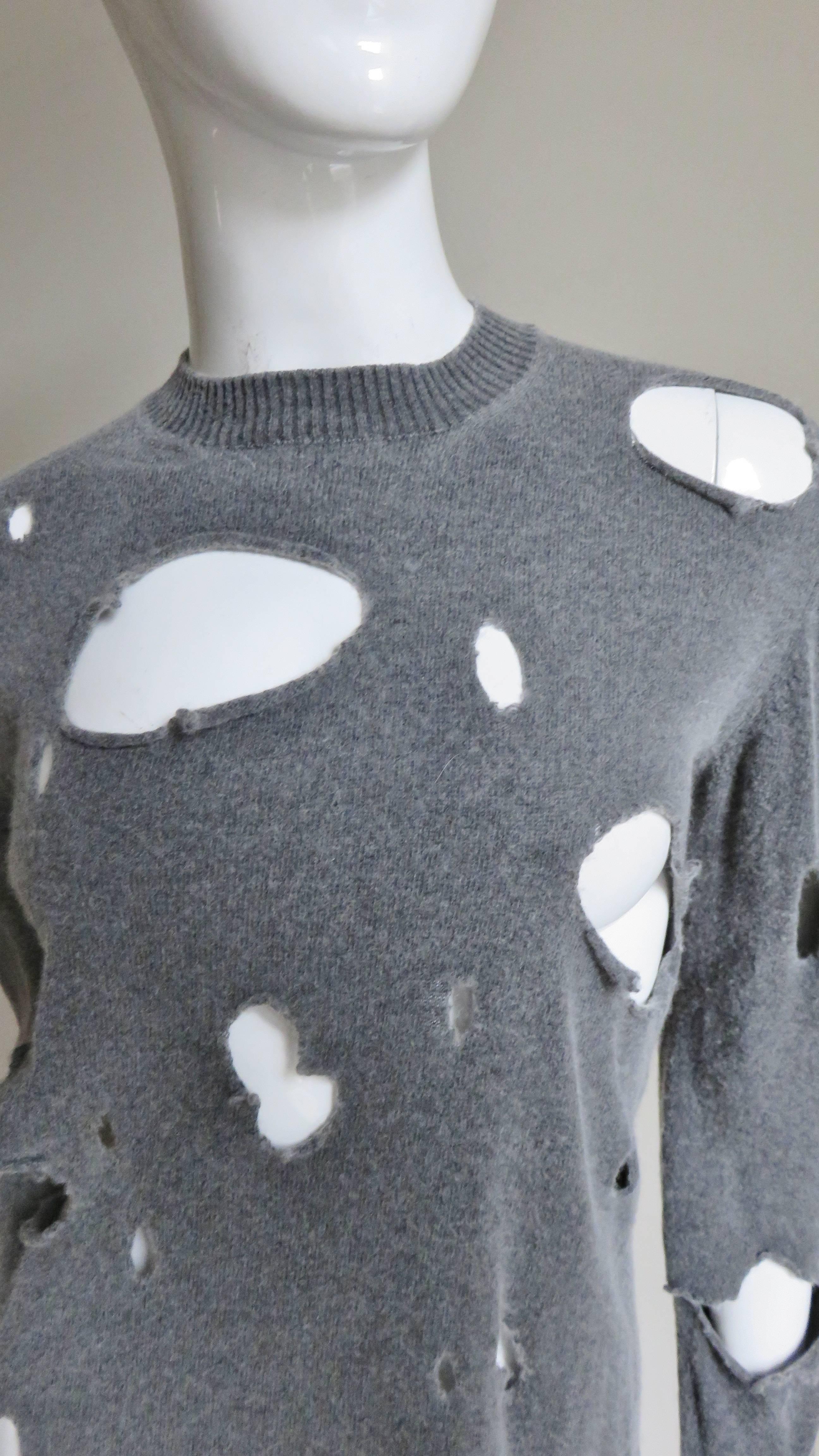 A fabulous grey wool sweater by Junya Watanabe for Comme des Garcons.  It has a crew neckline, long sleeves and is covered in strategically placed holes of varying sizes.  
Excellent condition.  Fits sizes Small, Medium, Large.

Bust 
