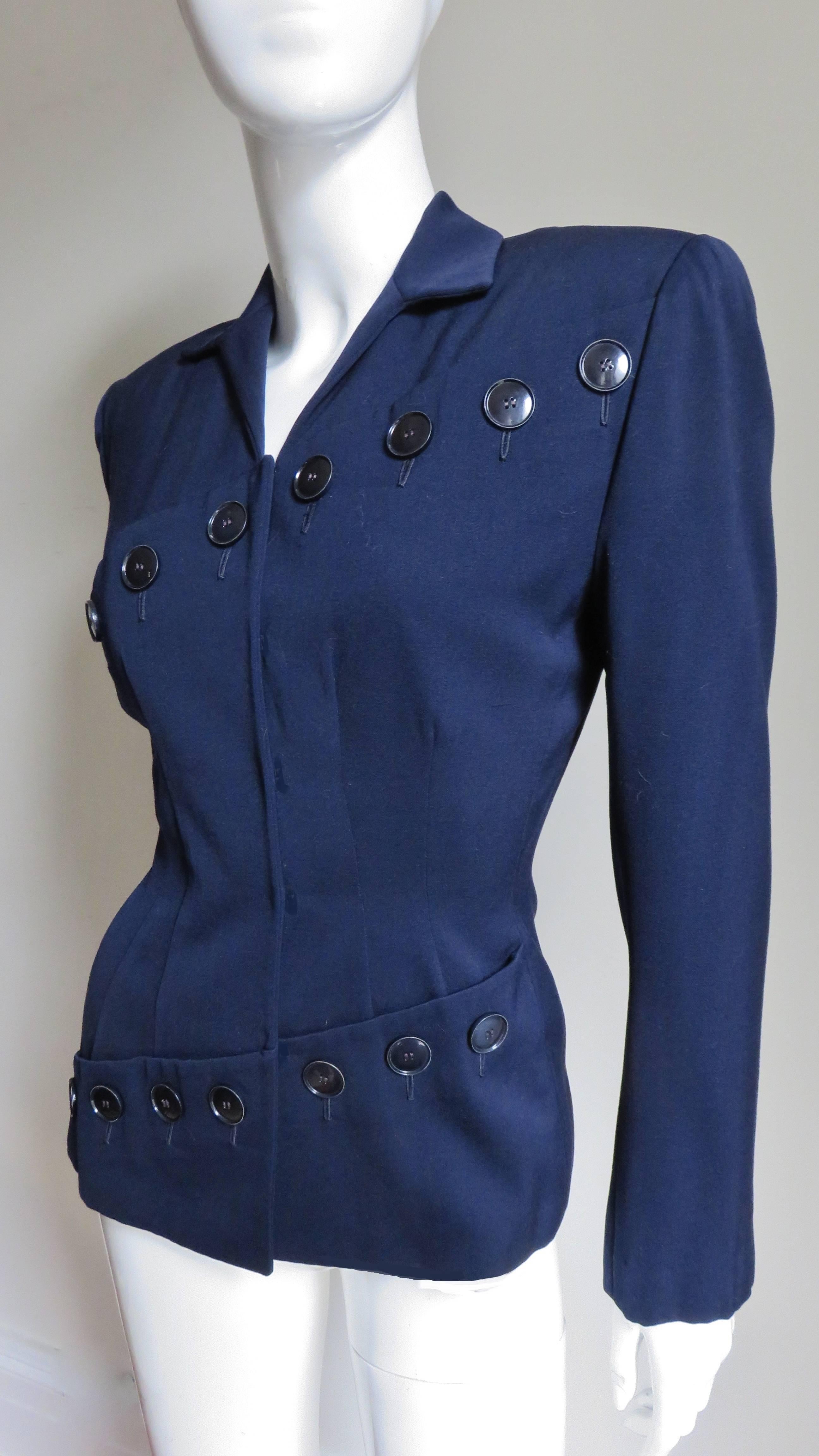 A fabulous navy wool jacket by Lilli Ann. It has the dramatic look of the 1940's with the shoulder padding and nipped in waist. The jacket is unique with the double diagonal row of buttons one across the chest and the other across the hips.  It is