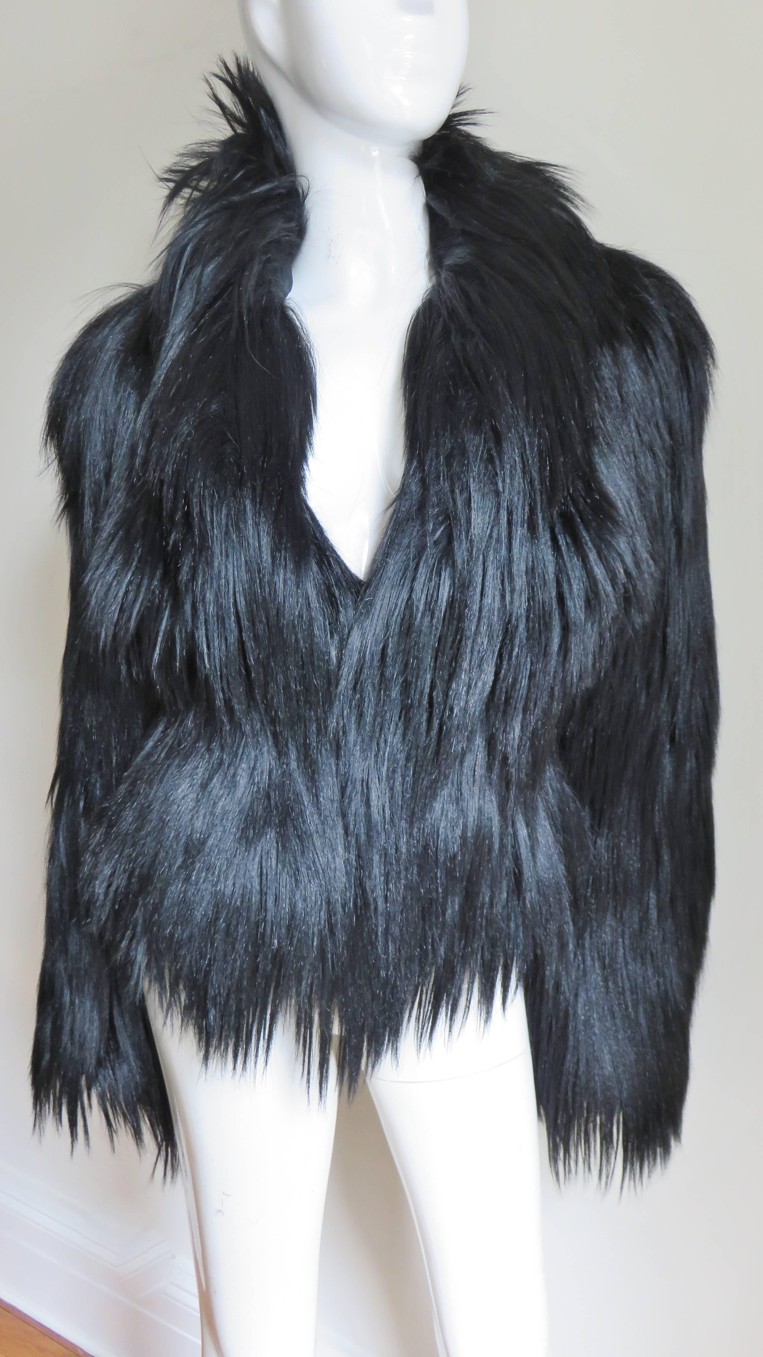This is an incredible black shiny, soft and silky goat fur jacket from Alexander McQueen.  It has a V neckline, front fur hook closures and is lined in black silk.  The entire jacket  has long silky black goat hair draping luxuriously throughout
