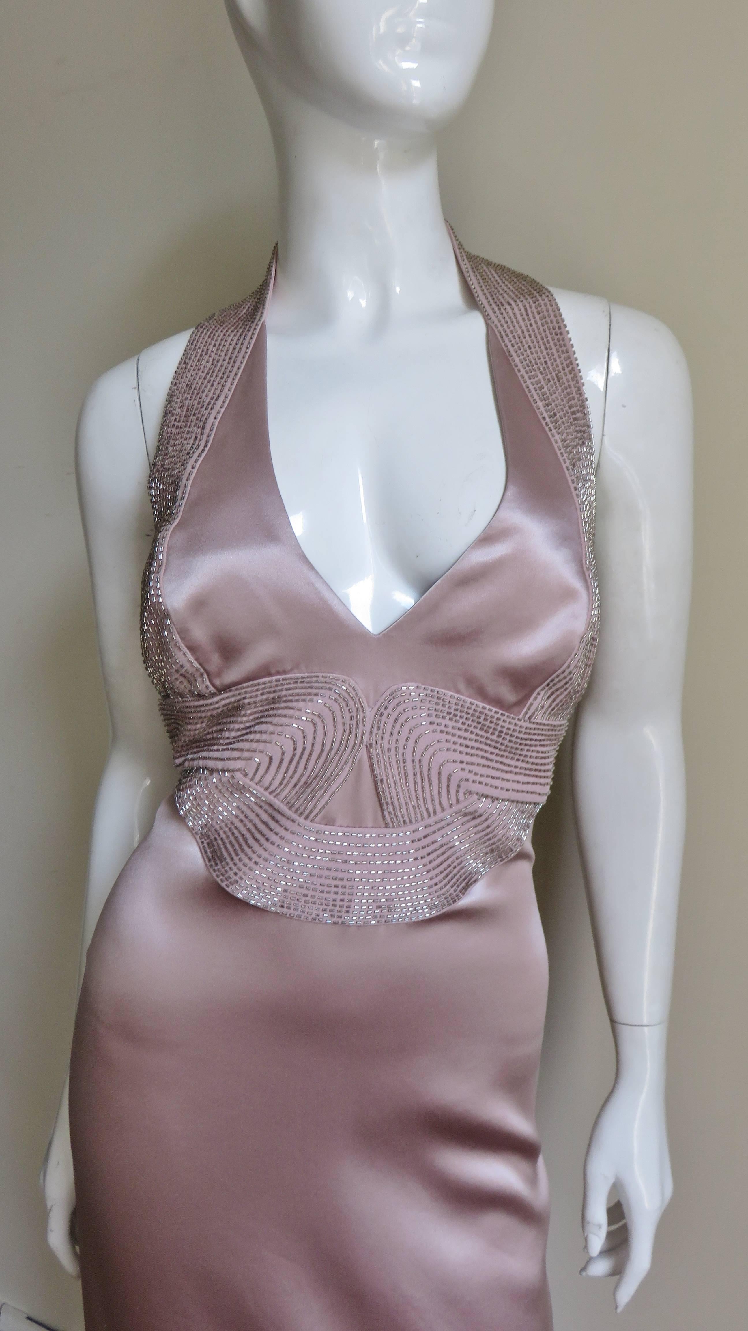 A fabulous blush pink silk charmeuse dress from Versace.  It is plunging neckline halter style with a band of rows of tubular glass beads around the neck, along the bodice sides, swirling, intertwining at the front midriff creating a 3D effect then