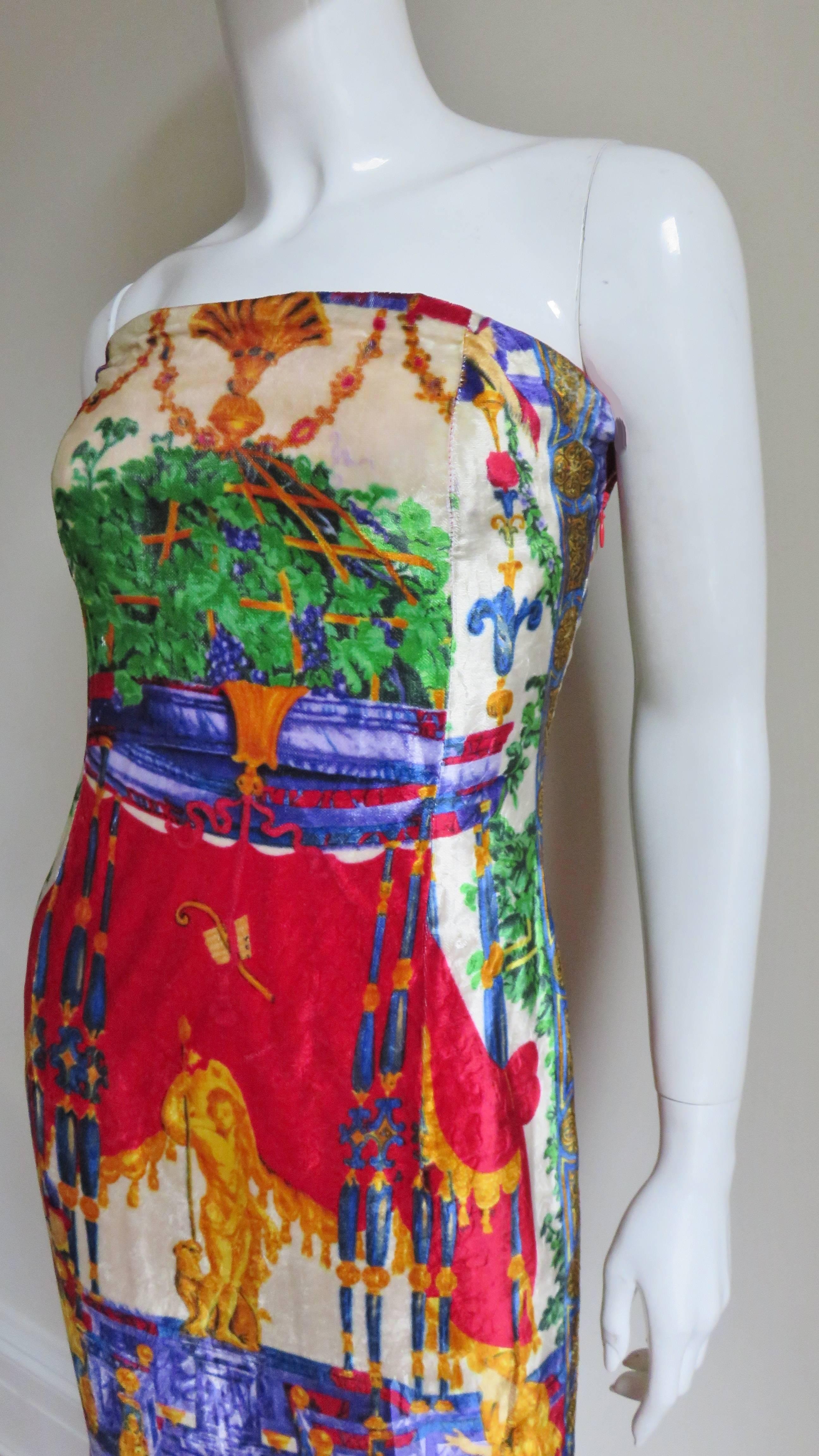 A beautiful, simple silk velvet strapless dress intricately patterned in the brightly colored elaborate detail that Gianni Versace was famous for - maidens, flora, fauna and statues set against elaborate backdrops (the front of the dress different