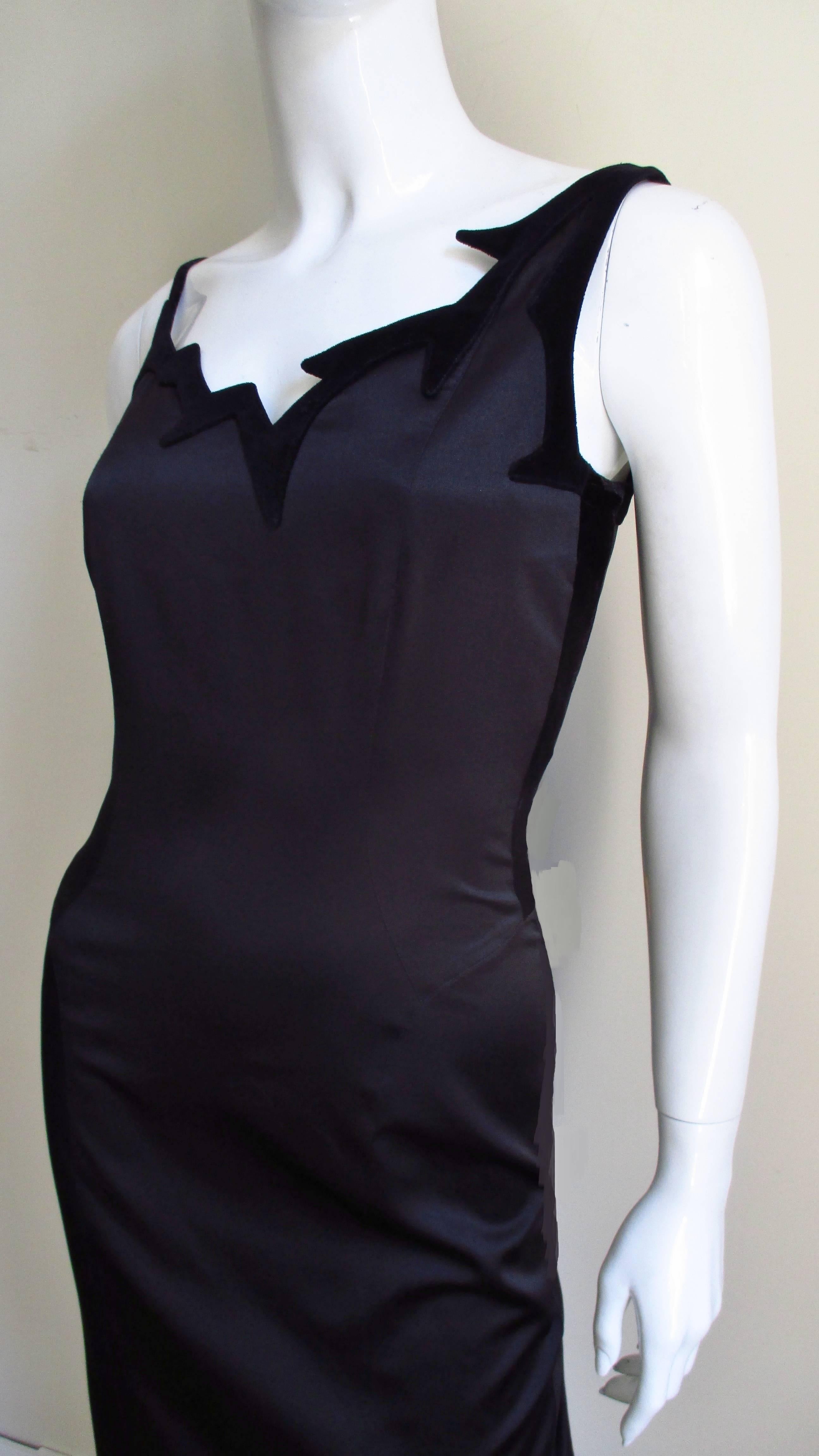 A fabulous black silk dress by Thierry Mugler. It is a semi fitted dress with an asymmetric jagged edge neckline outlined in black velvet and a straight skirt. It is fully lined in silk and has a center back invisible zipper.
Fits sizes Small,