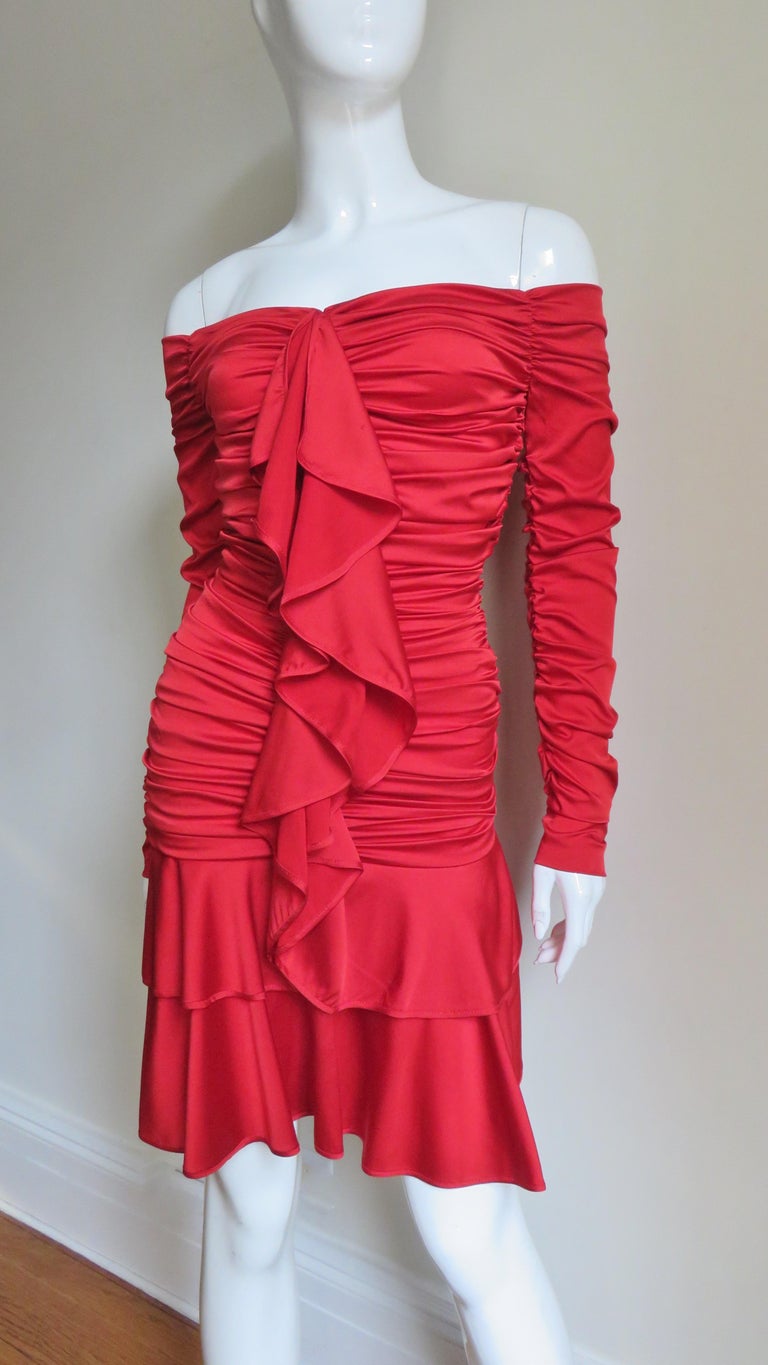 A fabulous red fine silk dress with stretch by Angelo Tarlazzi.  It exposes the shoulders and has horizontal ruching across the front and back down to the skirt and across the sleeves.  The dress zips up the front with a zipper under the front