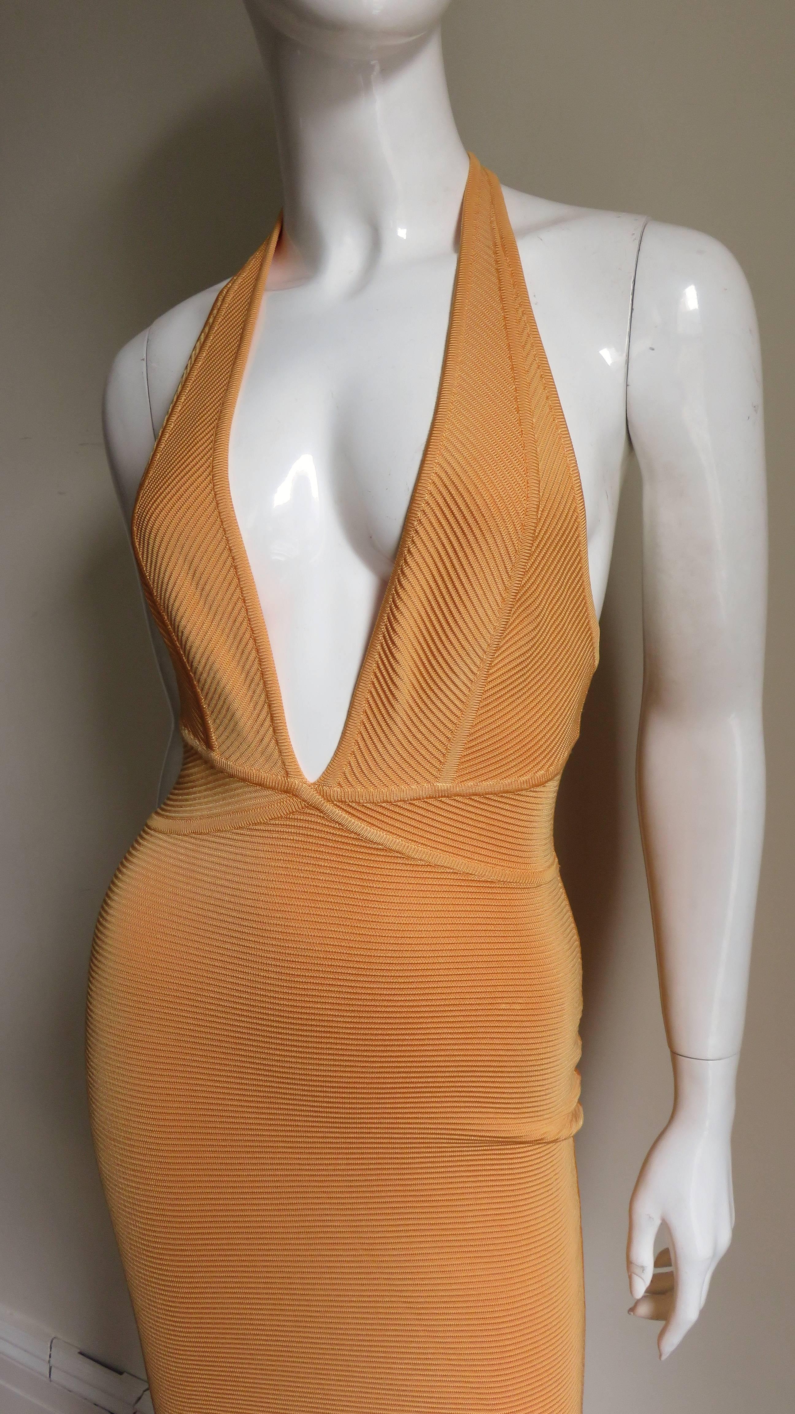 Another fabulous bandage dress from the master Herve Leger in a beautiful creamsicle color. After selling his name in the 1990s he continued designing under his Herve Leroux label.  It has a deep plunge neckline and angled seaming at the waist.  The