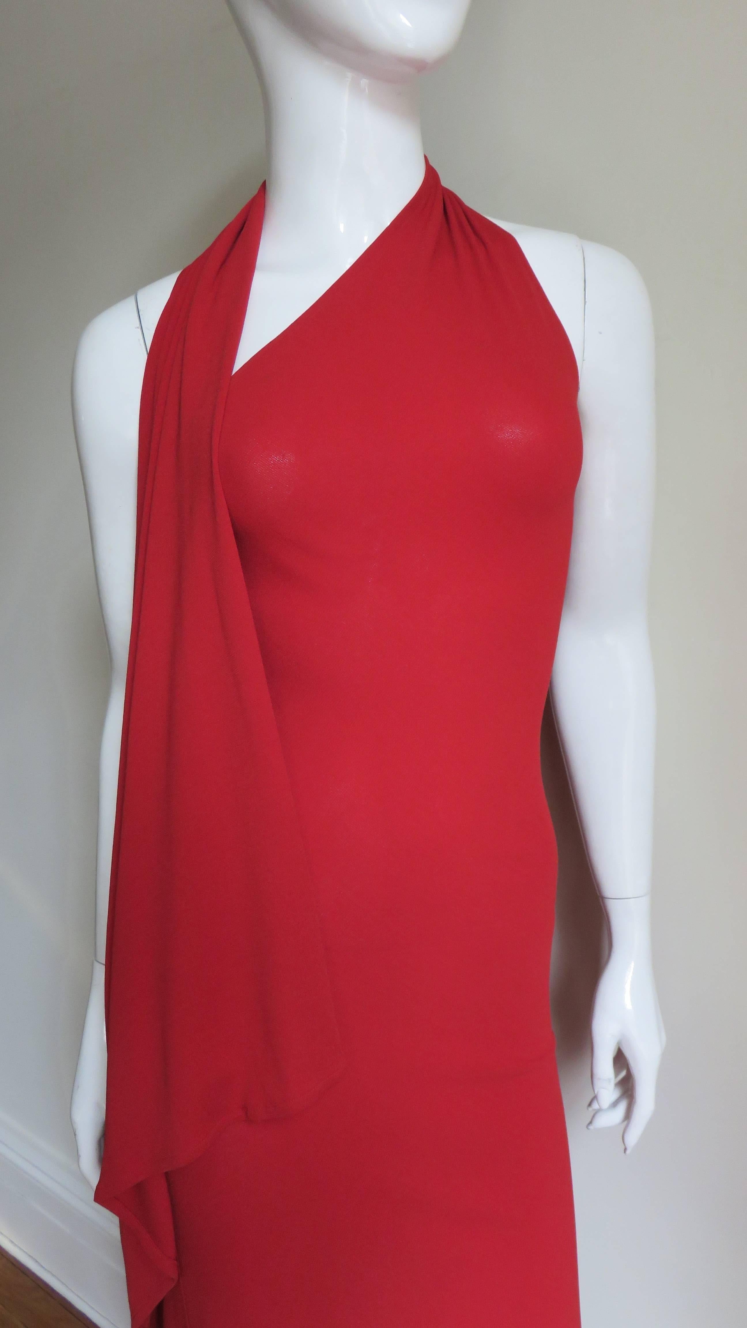 A pretty red jersey dress by Donna Karan.   It is fitted with a wrap halter that drapes along one side.  The back is bare to below mid back.  It slips on over the head, has a button under the drape for the halter and is unlined.  
Fits sizes Small,