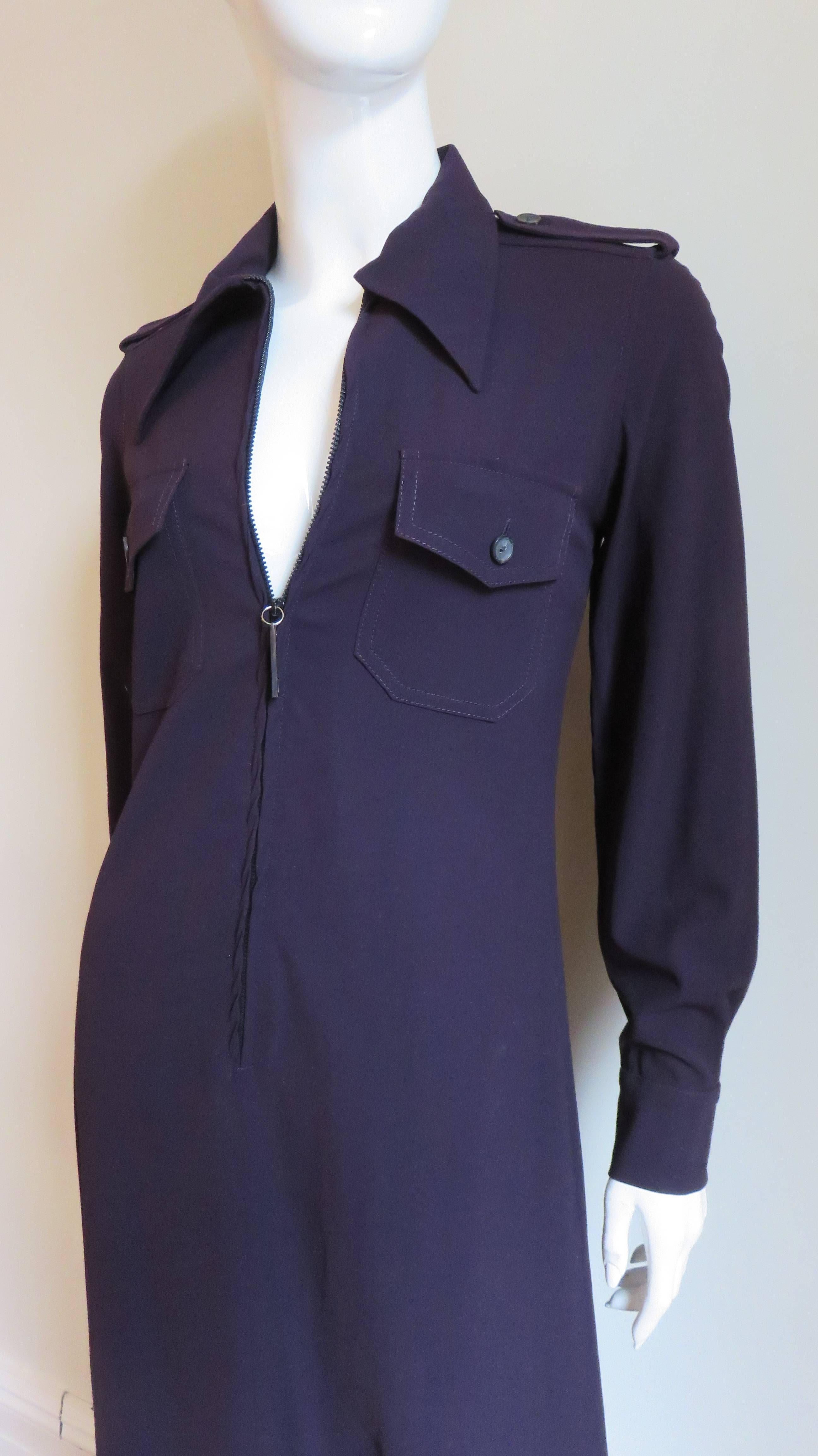 A fabulous eggplant purple stretch wool shirtwaist dress from Gucci. It has a shirt collar, 2 chest button flap pockets, button cuffs, epaulets along each shoulder, a back yoke and front zip with a metal G pull. The dress forms a subtle A line