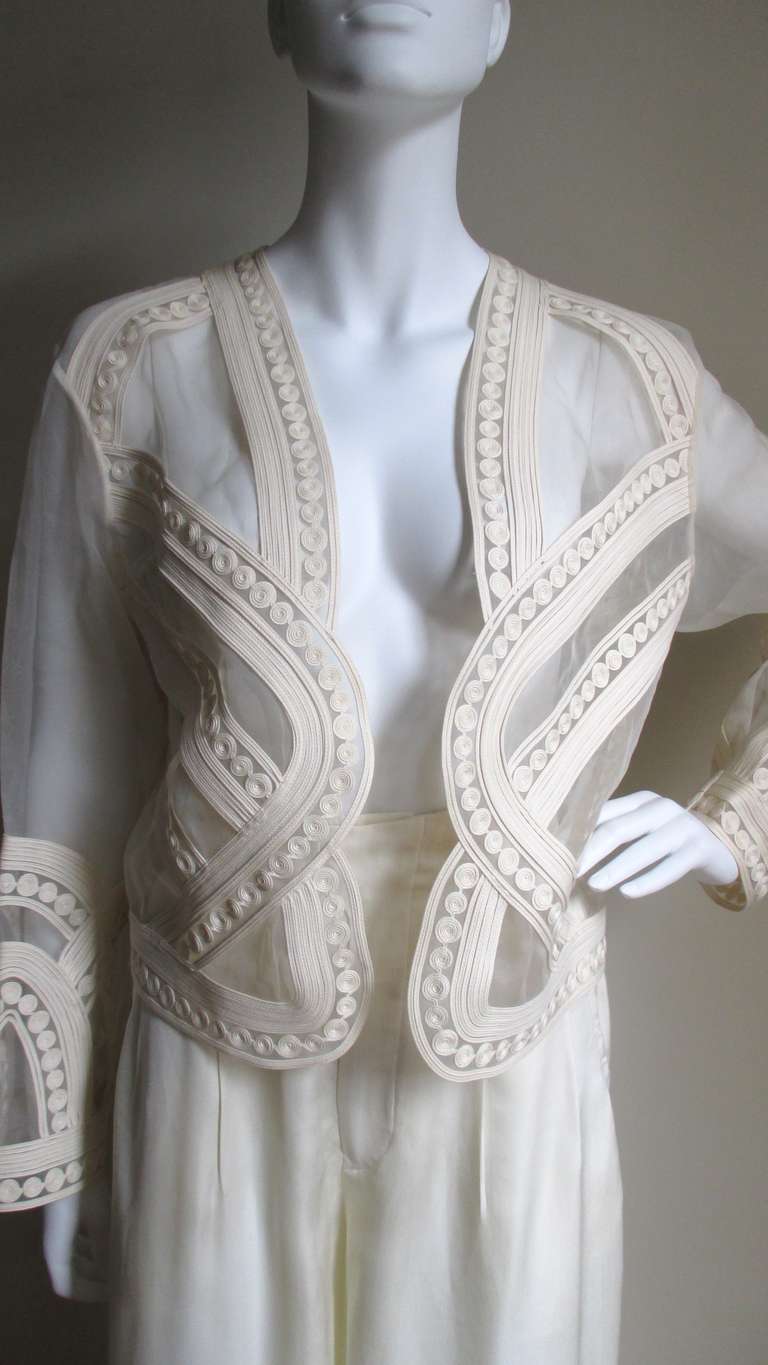 A stunning and work intensive off white silk pant and jacket set from Matsuda.  The sheer (durable not fragile) jacket is open style and covered in elaborate corded passementerie in patterns of lines and circles crossing and intersecting giving a 3