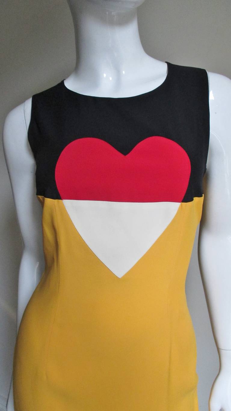 A great color block dress from the Moschino Couture in yellow, red, off white and black. The sleeveless fitted dress has a heart on the front and back with color blocking cleverly reversed on each side.  It is fully lined and has a side zipper. 
