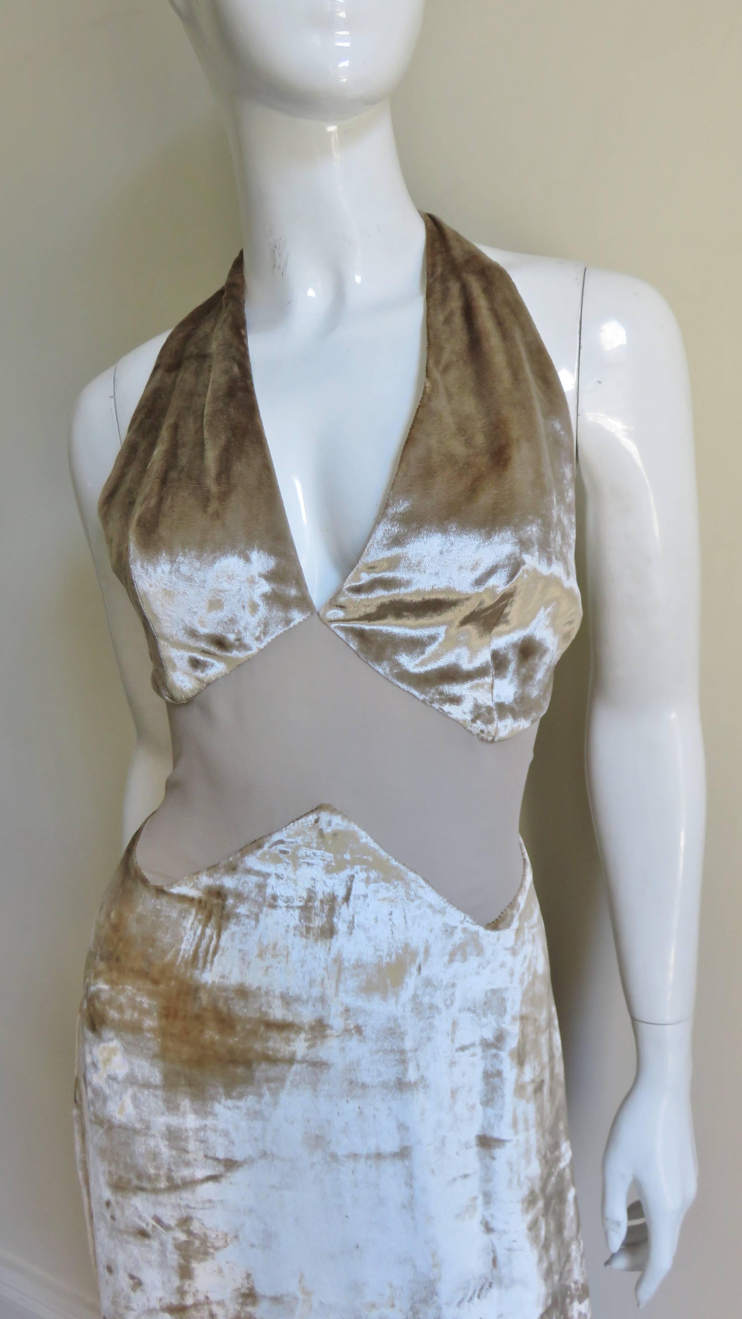 A fabulous beige silk velvet halter dress from Gianni Versace. It has a matching semi sheer silk inverted V cutout midriff.  The halter neckline plunges into a low V in the front and the back is bare to the waist. It is lined in matching silk and