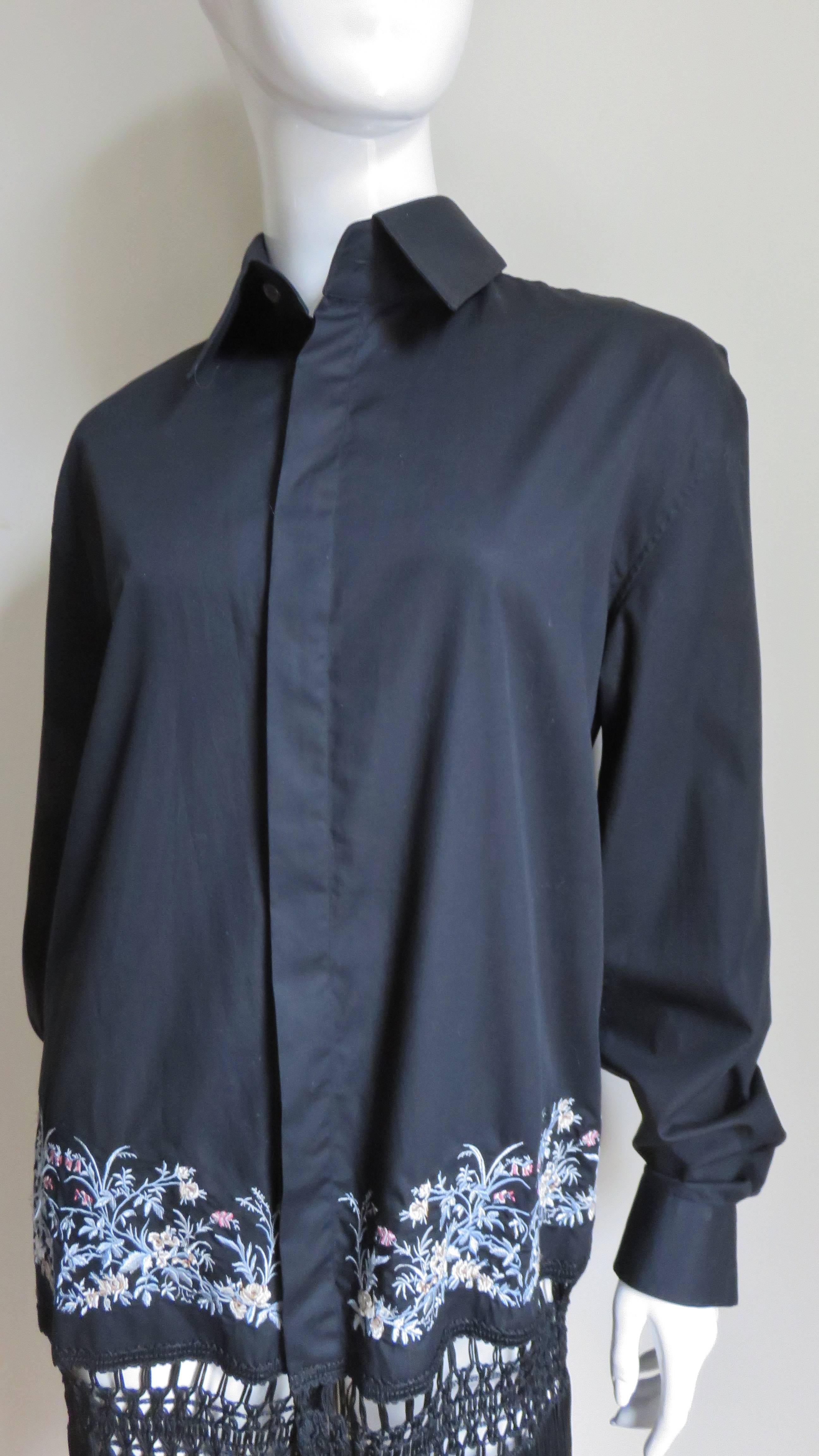 A fabulous black polished cotton shirt or dress by Alexander McQueen.  It has a shirt collar and button cuffs but differentiates itself with 3.50