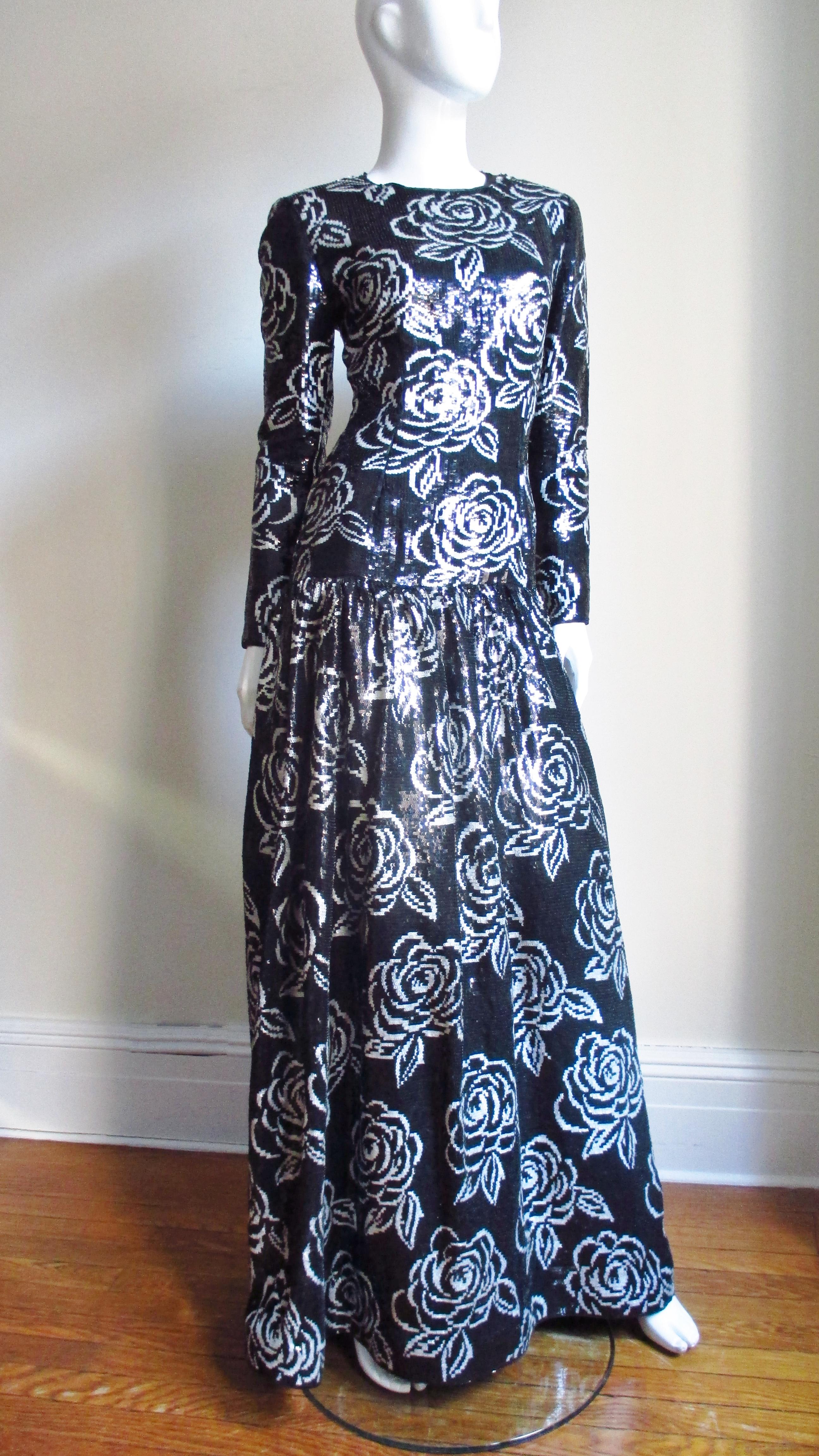 This is a work of art in black and white sequins by Oscar de la Renta.  It has long sleeves with zippers, a flattering fitted drop waist and a gathered skirt all completely covered in beautiful black and white sequins in a flower pattern on silk. 
