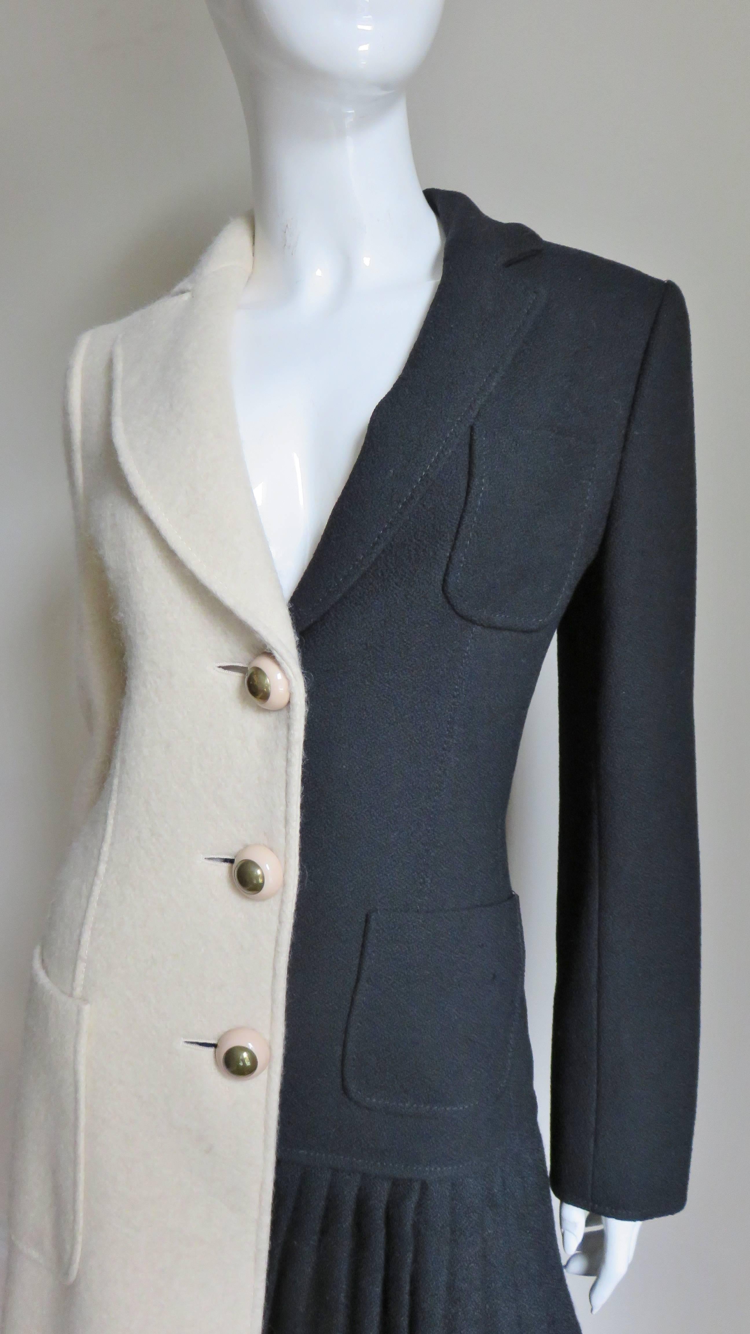 This is a fabulous half black, half off white wool coat from Moschino.  It has a lapel collar and hip patch pockets, the black side also has a breast pocket.  The off white side has a slight A line and the black has a pleated panel from hip to hem. 