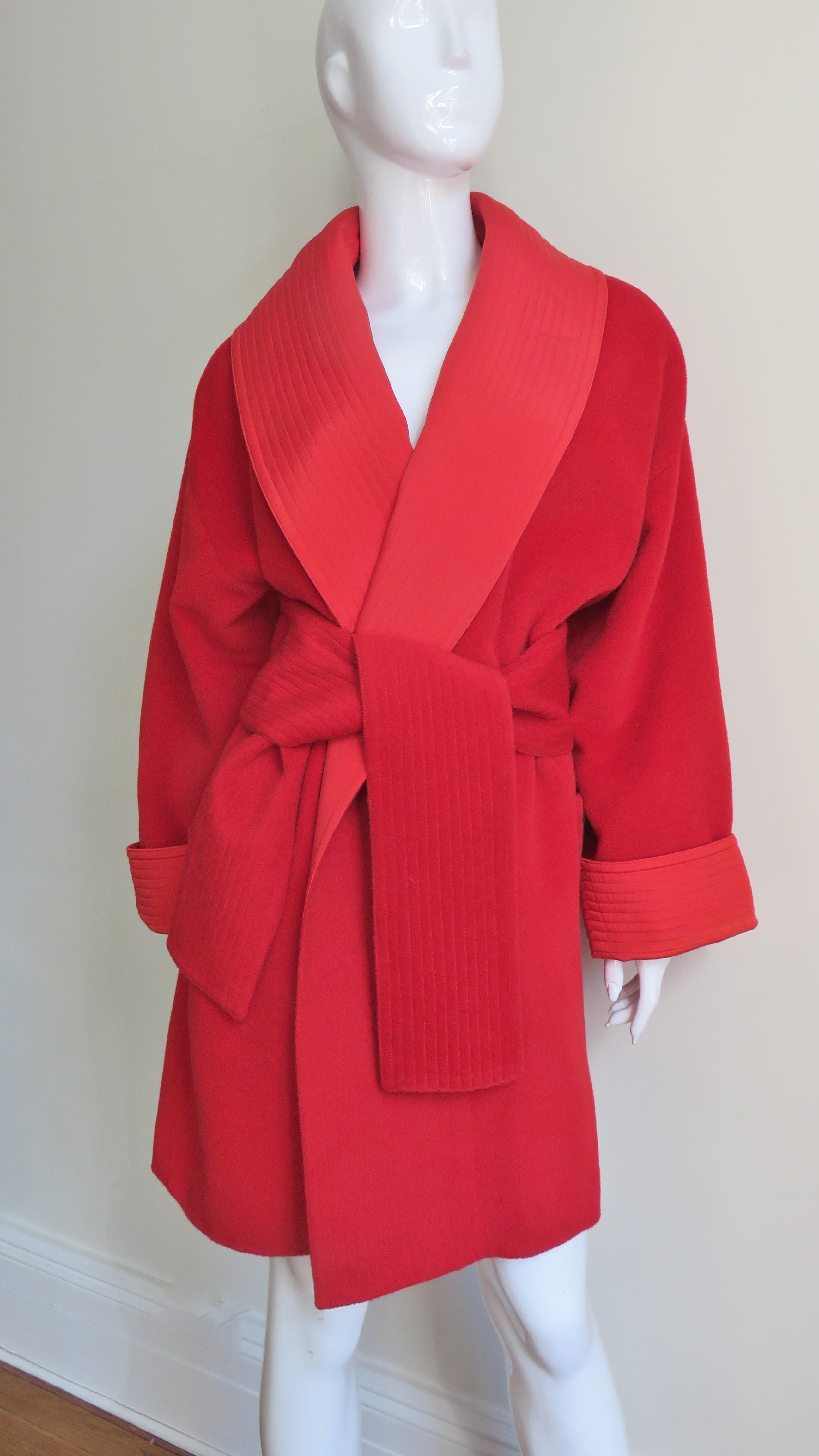 A fabulous wrap red wool jacket, coat by Gianni Versace.  It has a large shawl collar, generous fold back cuffs on dolman sleeves and a wide reverseable tie belt (wool on one side silk on the other) all with rows of topstitching on matching red silk