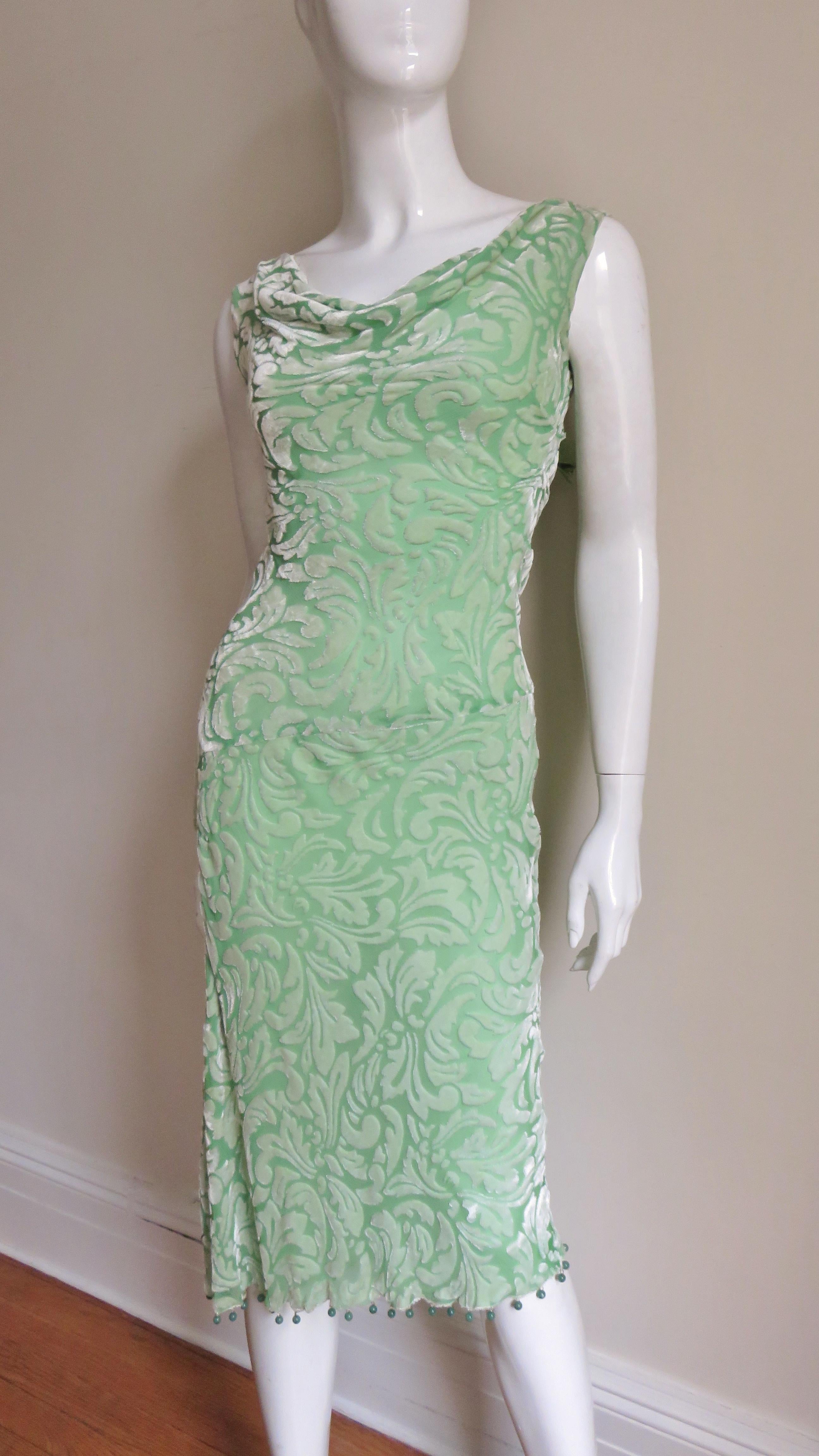 A fabulous light green silk cut velvet dress from Gianni Versace in a pattern of abstract scrolls, feathers and leaves.  Cut on the bias for a great fit it has a scoop neckline front and back. The skirt portion gently flares to the hem and has a 12