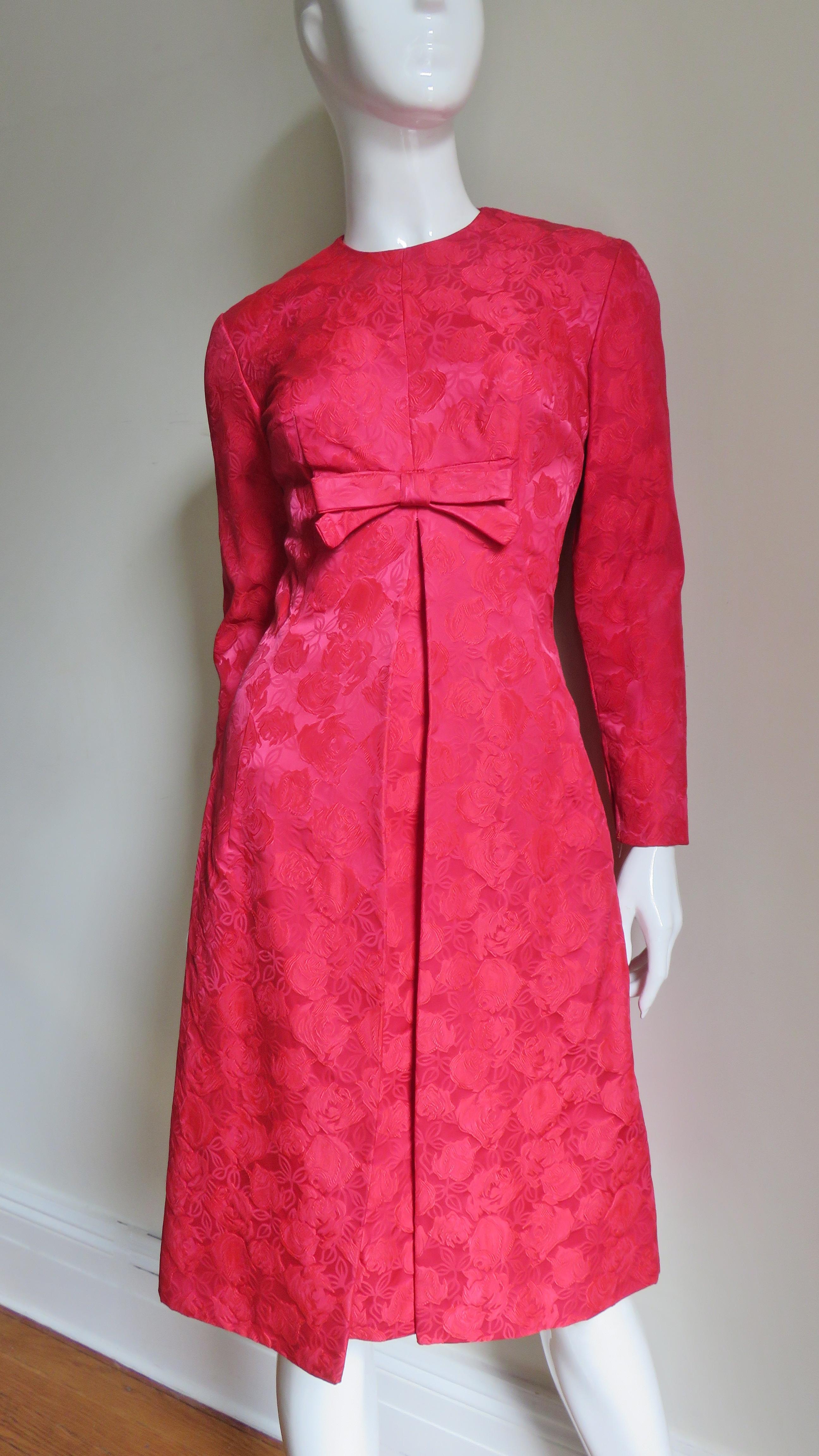 A rare dress set from Suzy Perette made in a rosy red detailed rose pattern damask.  It is actually 2 separate dresses - a fitted sheath underneath with a slightly flared dress over.  The sheath is sleeveless with a crew neckline.  The fitted long