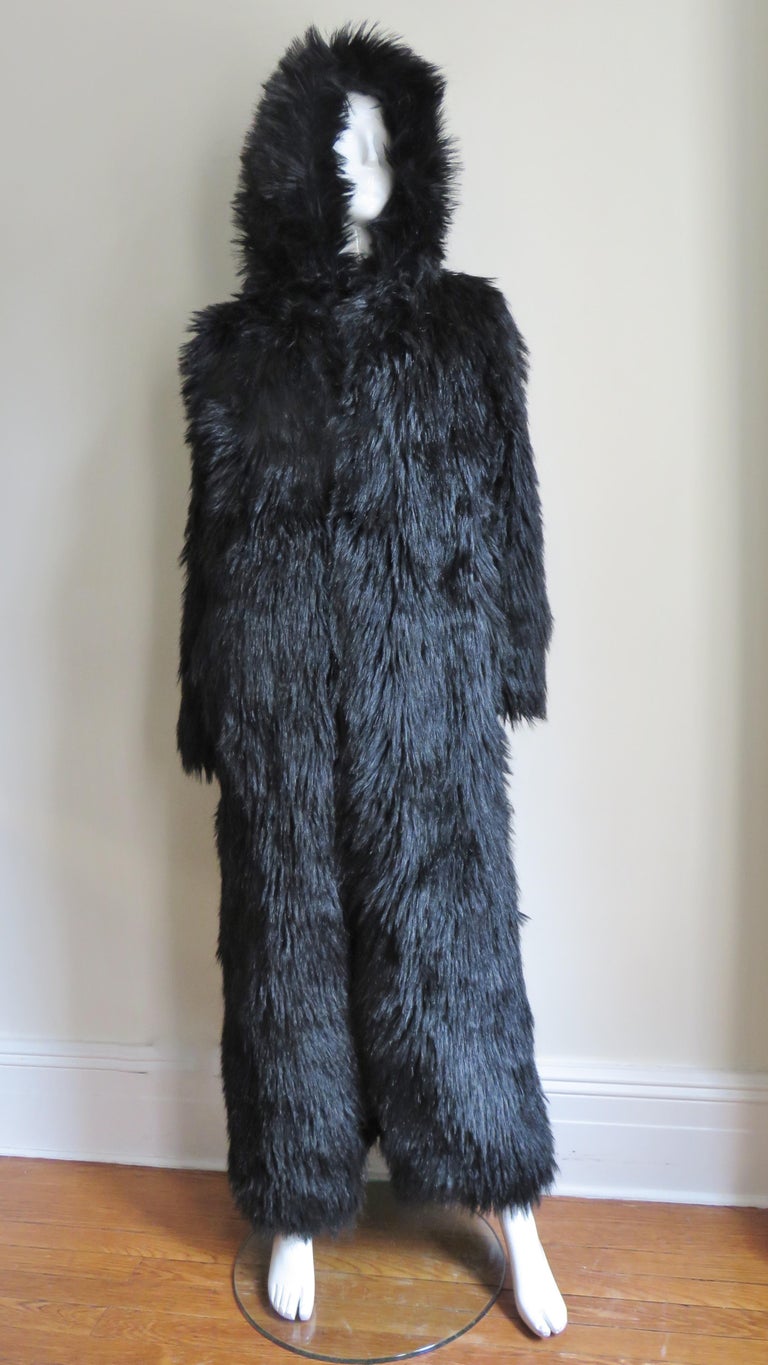 A fabulous black faux fur full length coat by Betsey Johnson.  It has a hood, side seam pockets and long soft luxurious faux fur.  It closes in the front with fur hooks and is lined in black. 
Fits sizes Small, Medium.  Marked US size S.

Bust 