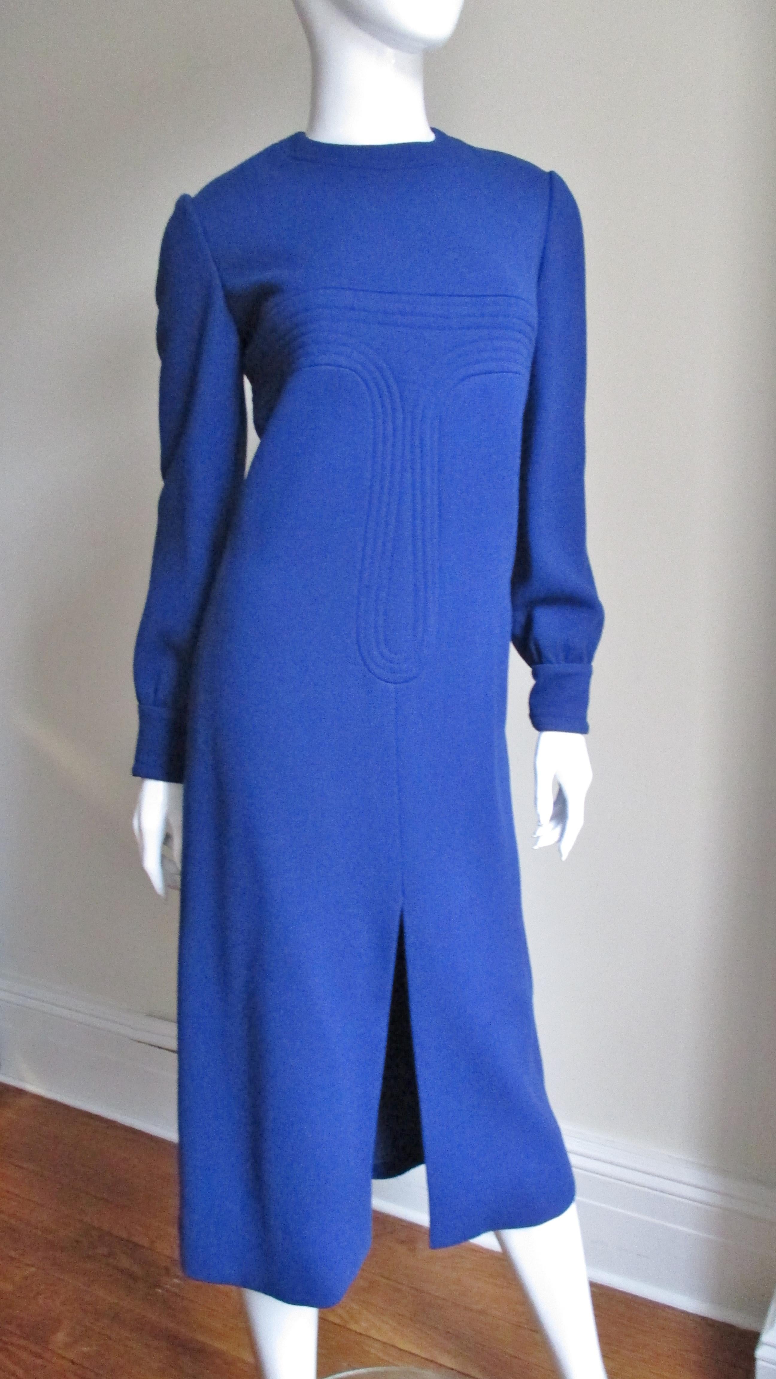 A great bright blue wool dress from Pierre Cardin.  It has the simple A line midi length shift with a center front slit.  Across the bust through to the hips and center back are elaborate lines of trapunto embroidery which give the dress a little