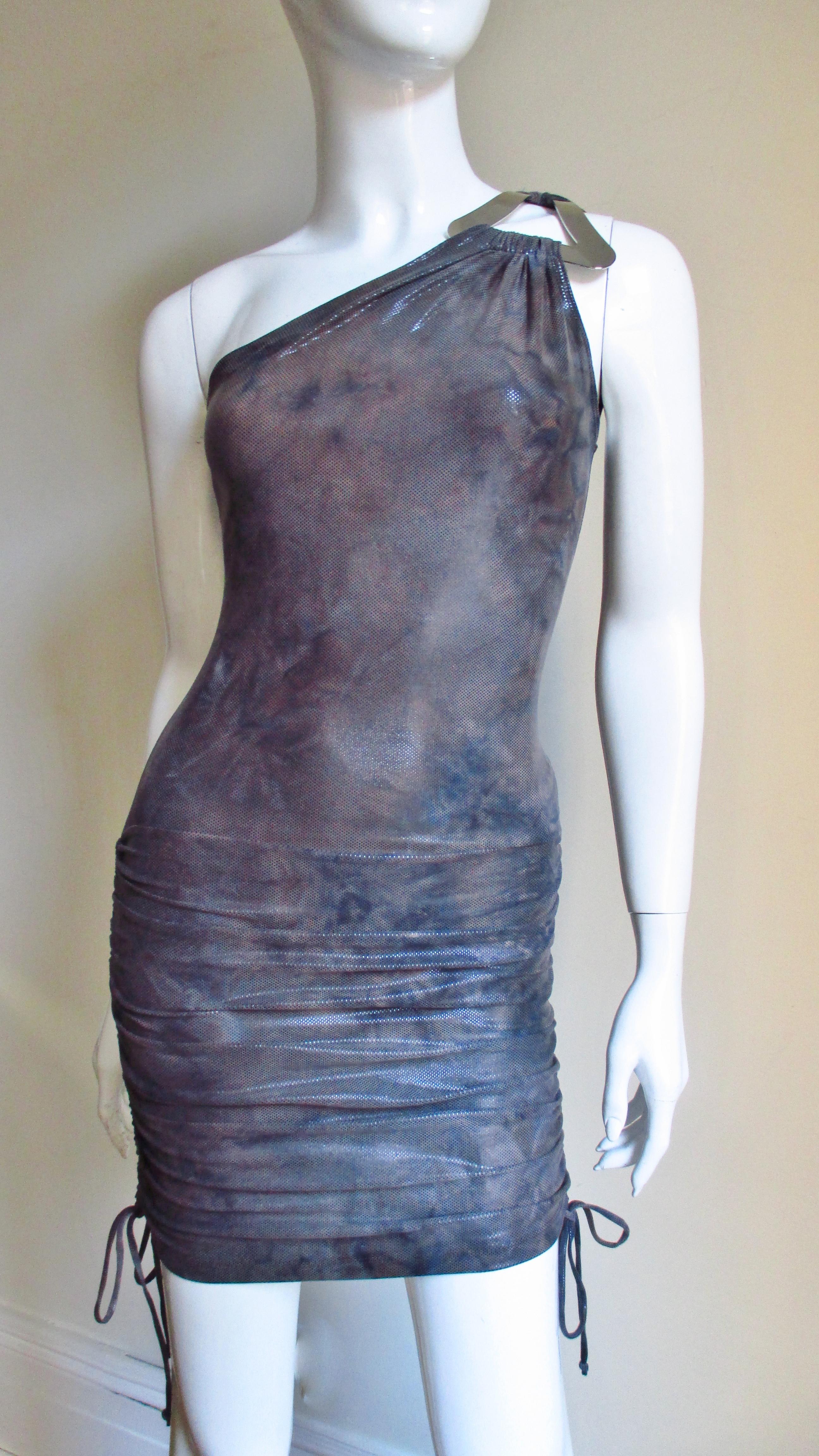 In muted shades of grey a fine jersey dress from Gianni Versace Couture.  It has one shoulder with a silver metal triangle joining the front and back.  The dress is fitted through to the hips and has drawstrings on the skirt sides to adjust it's