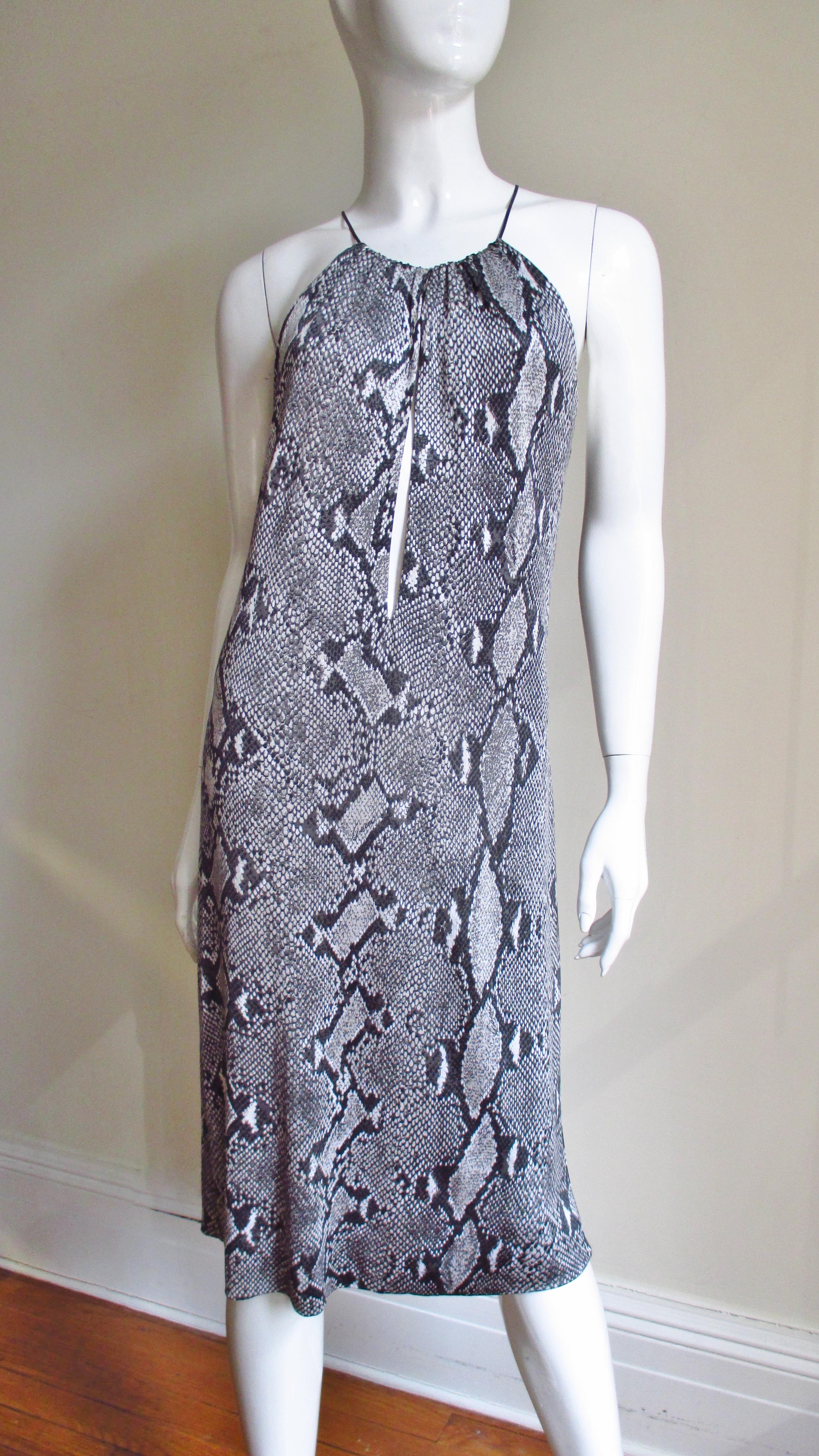 A fabulous iconic python print silk jersey dress from Tom Ford for Gucci S/S 2000 collection in shades of grey.  It has a leather cord closing with a 
Gucci inscribed silver metal clasp at the neckline onto which the front and back of the dress are