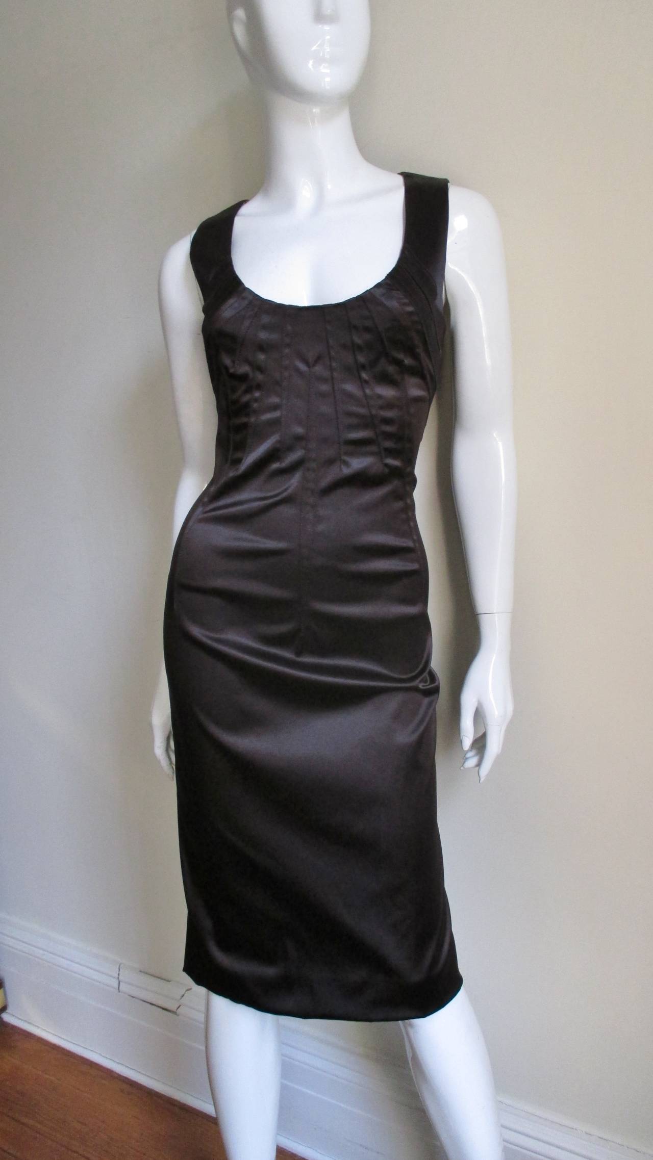 A Dolce & Gabbana silk fitted dress in a rich dark brown with elaborate top stitched darting detail fanning out from the scoop neckline front and back.  It has a center back zipper and leopard silk lining. 
Fits size Small, Medium.

Bust  34