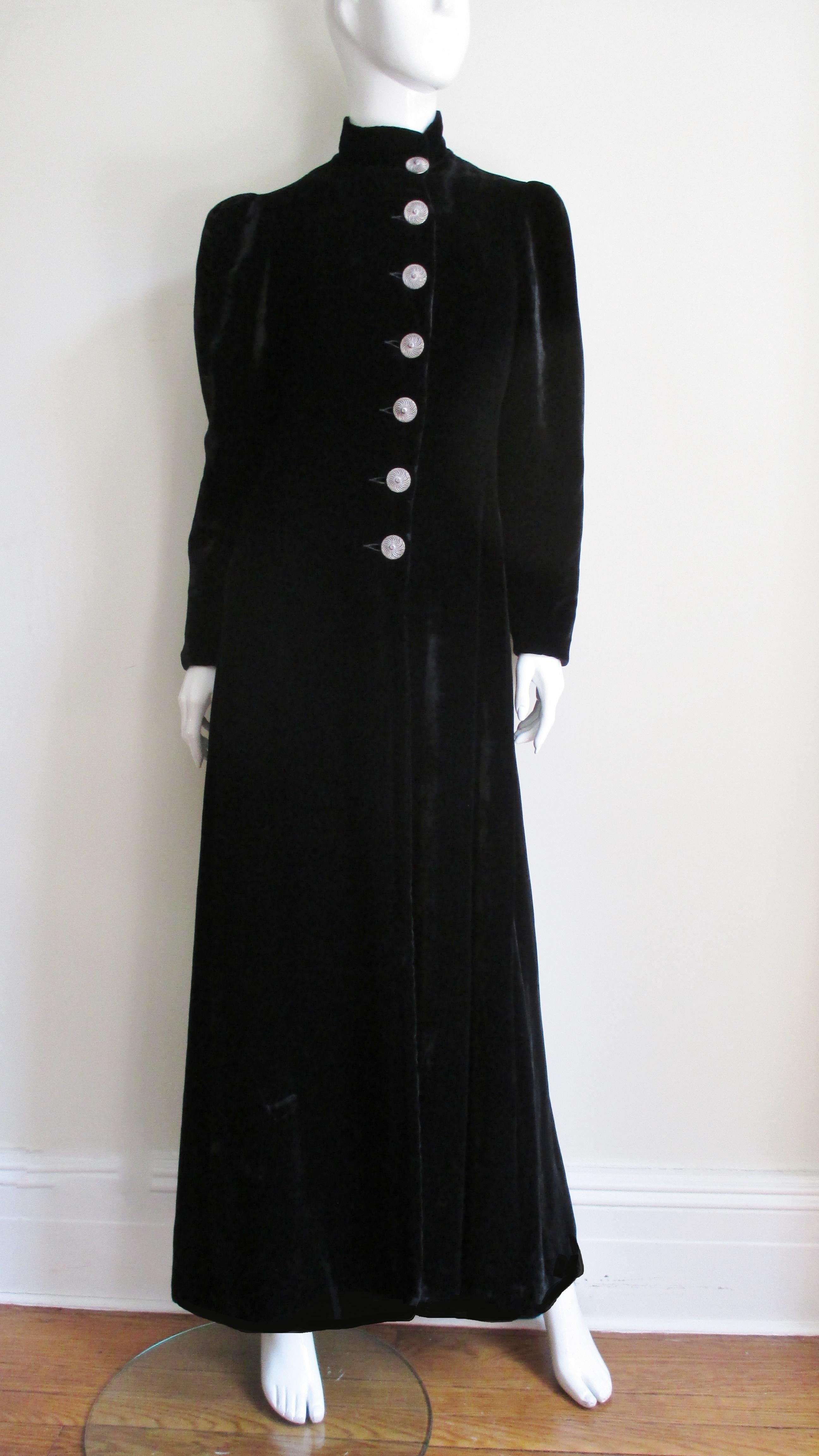 A gorgeous full length black silk velvet coat with the long elegant lines of the 1930s labelled 'Gladding's, Providence Since 1766'.  It has long sleeves darted a the shoulders to add fullness, a stand up collar and 7 beautiful, large silver