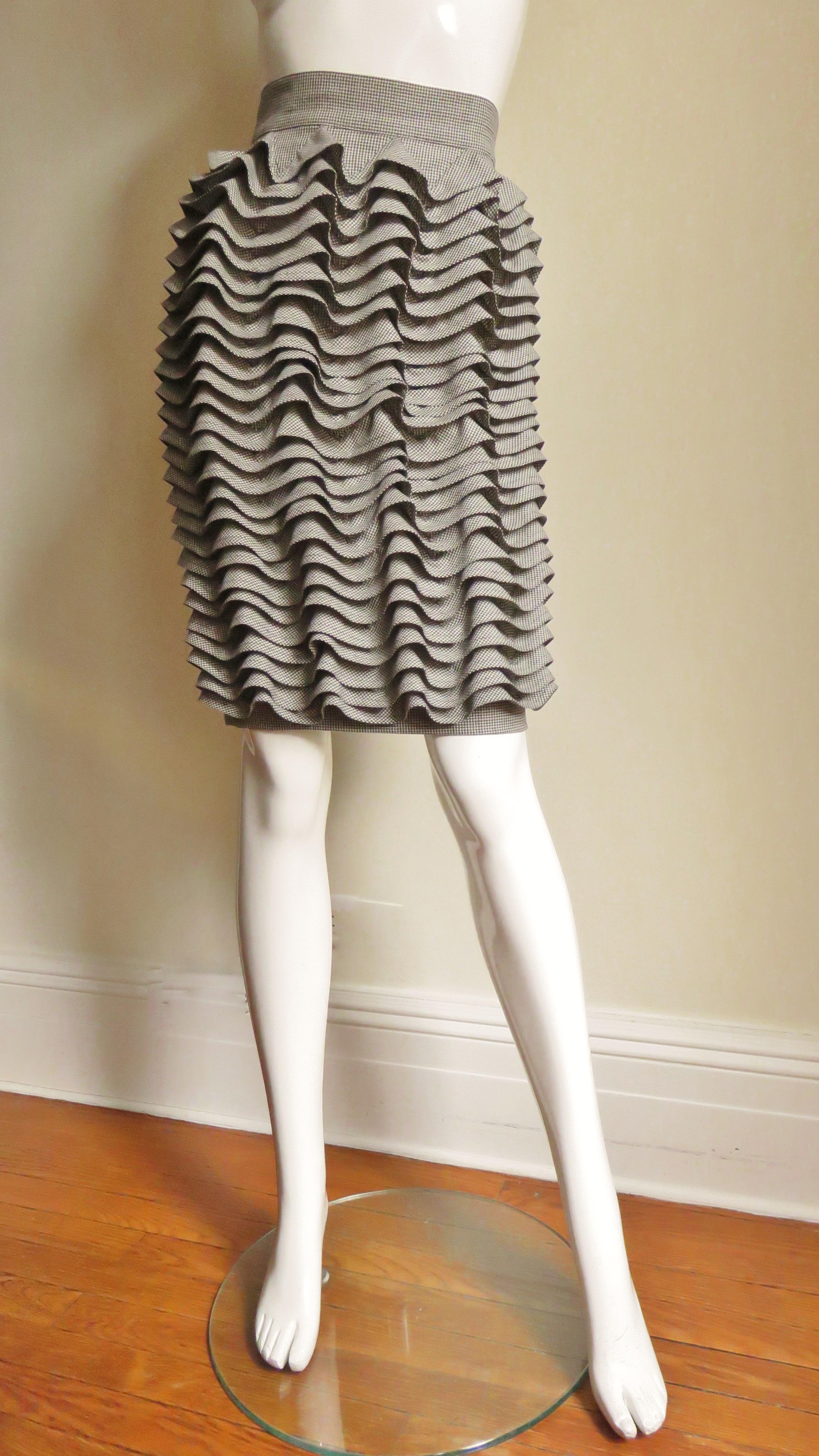 A fabulous light weight wool in an off white and black hounds tooth print ruffle skirt from Gianni Versace Couture.  It is pencil style with a waistband and row upon row of ruffles around it's circumference from top to bottom. It has a center back