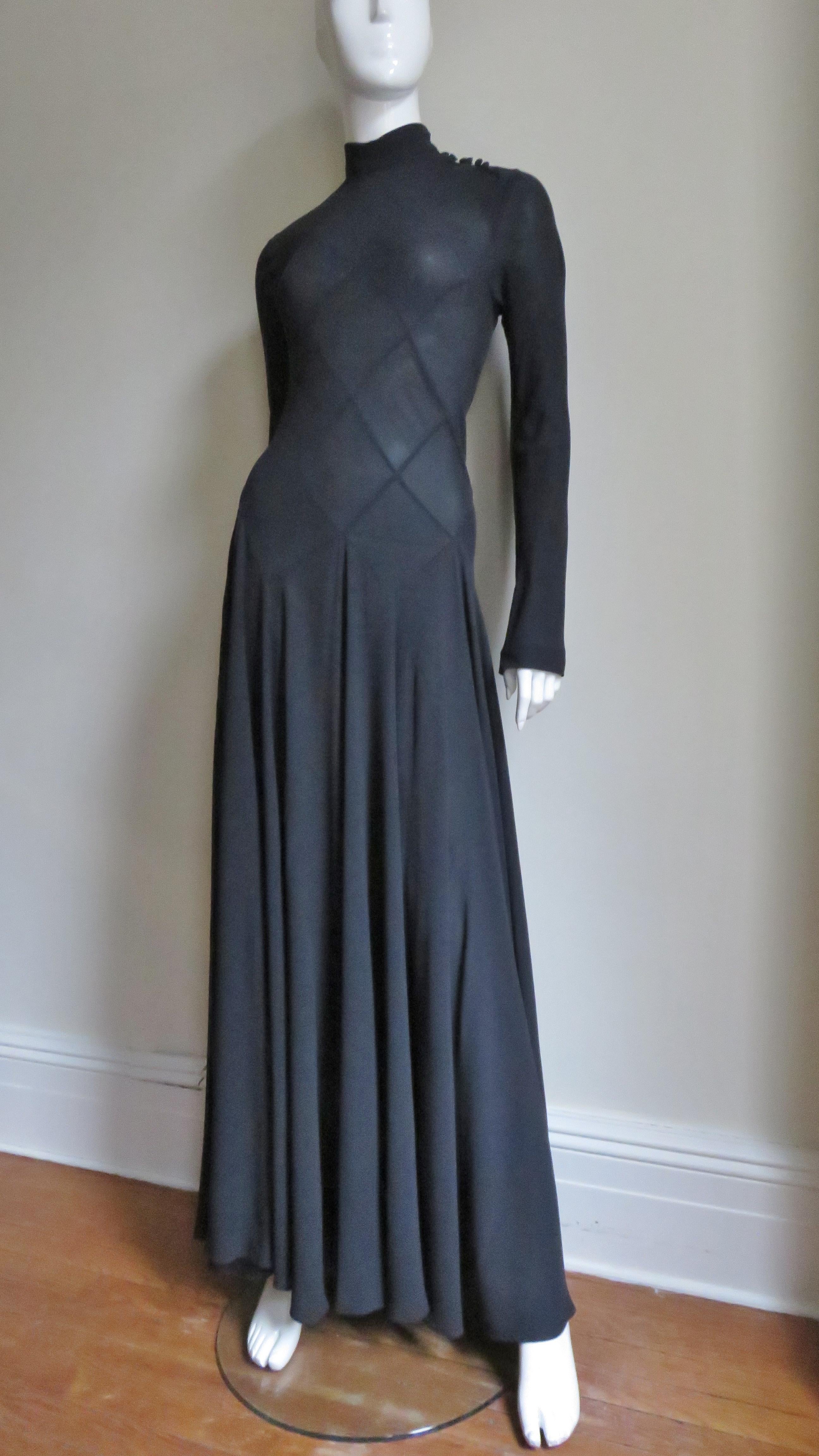 A gorgeous black fine silk dress gown from Calvin Klein. The detail is amazing in the intricate assembling of diamond shapes forming the bodice through to the hips. It has a stand up collar with small self covered buttons along one side of the neck