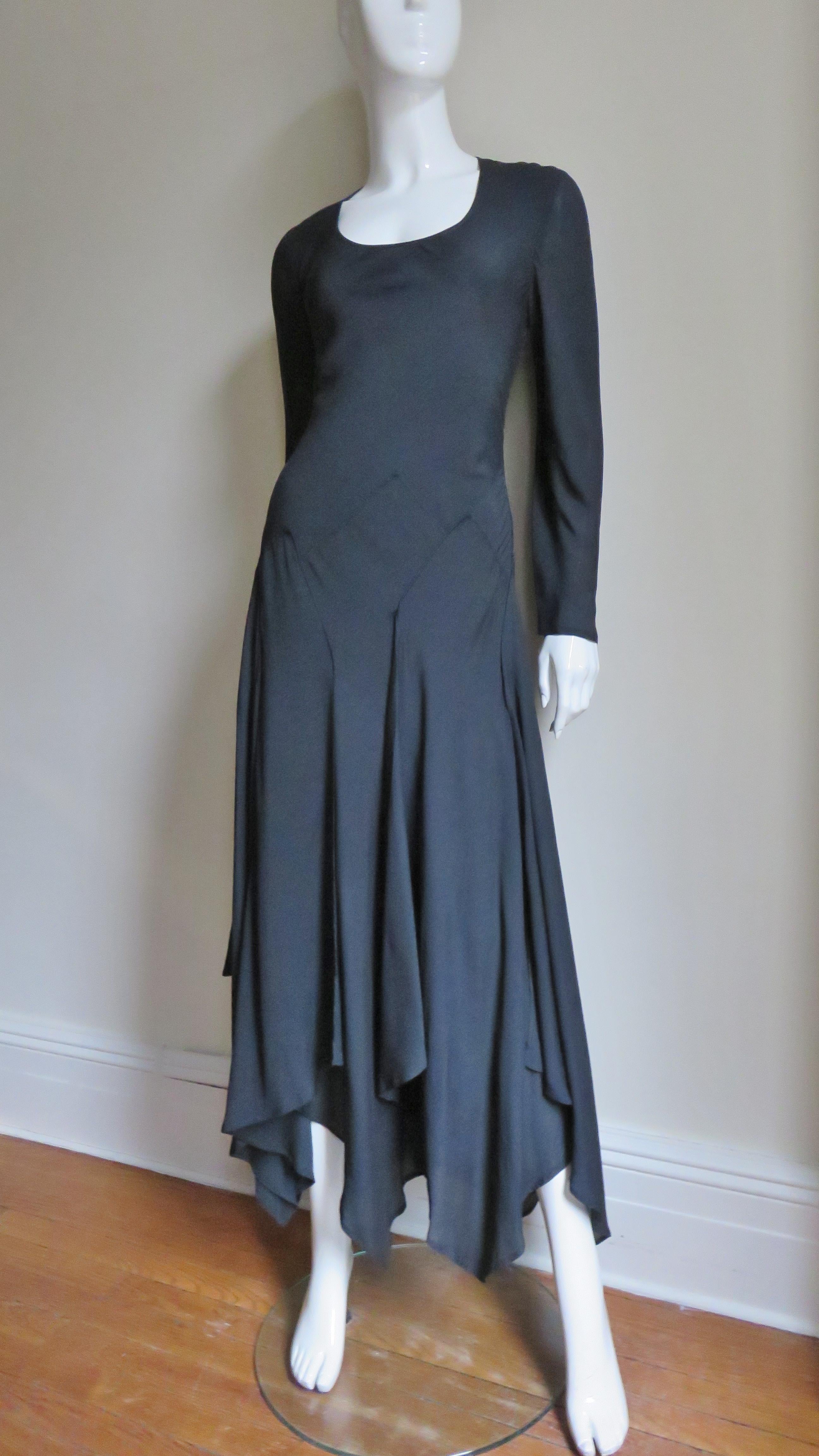 A fabulous black fine stretch silk dress from Jil Sander.  It has a scoop neckline, long sleeves and panels draping in folds and points to the hem. The dress is cut on the bias for a great flexible fit and slips on over the head. Marked Italian size