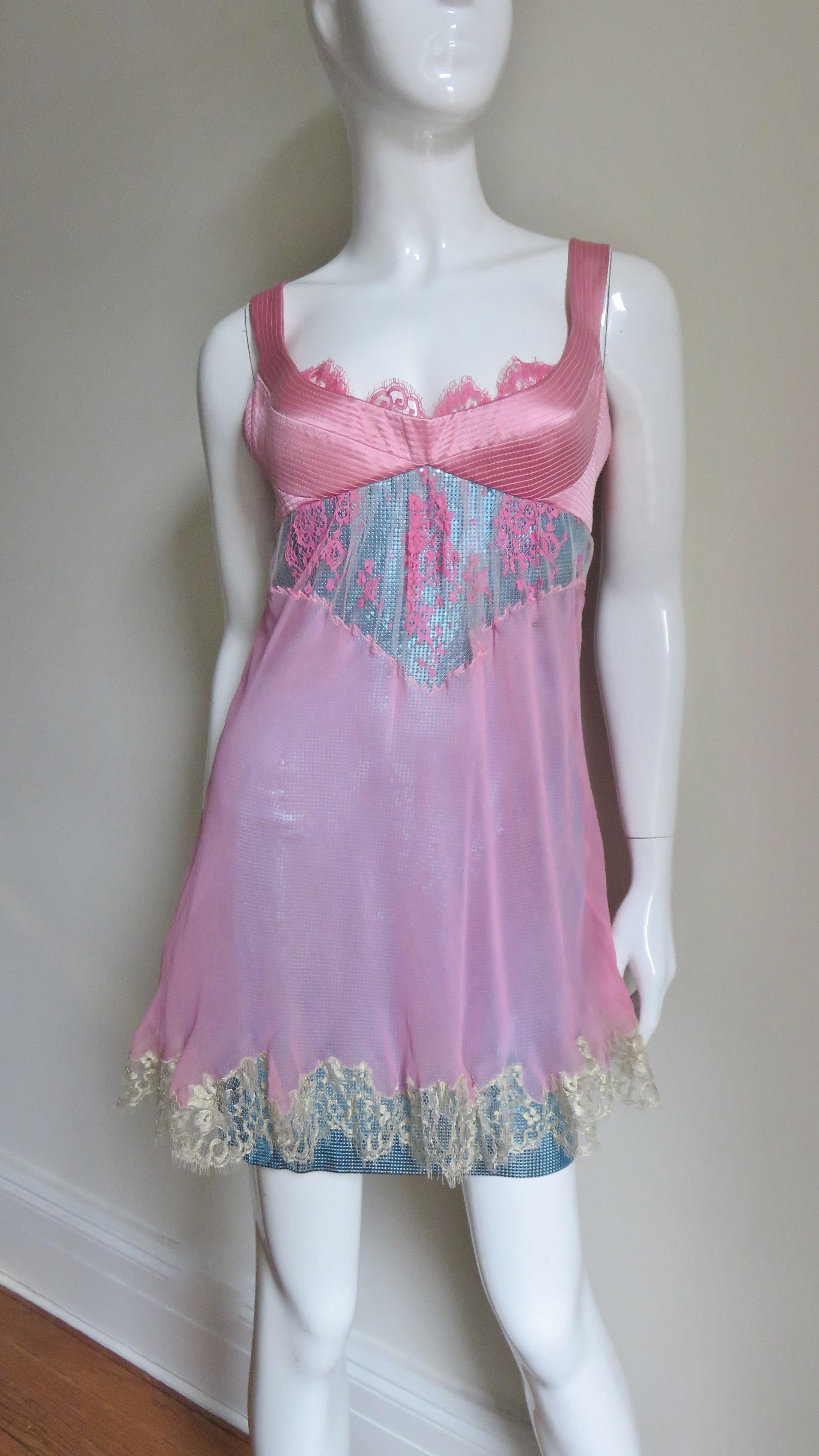 Gianni Versace was a master at combining textures, colors and shapes and this dress gorgeously embodies it all. The body of the dress is a beautiful blue metal mesh or chain mail dress attached to a pink multi top stitched bra cut top with a lace