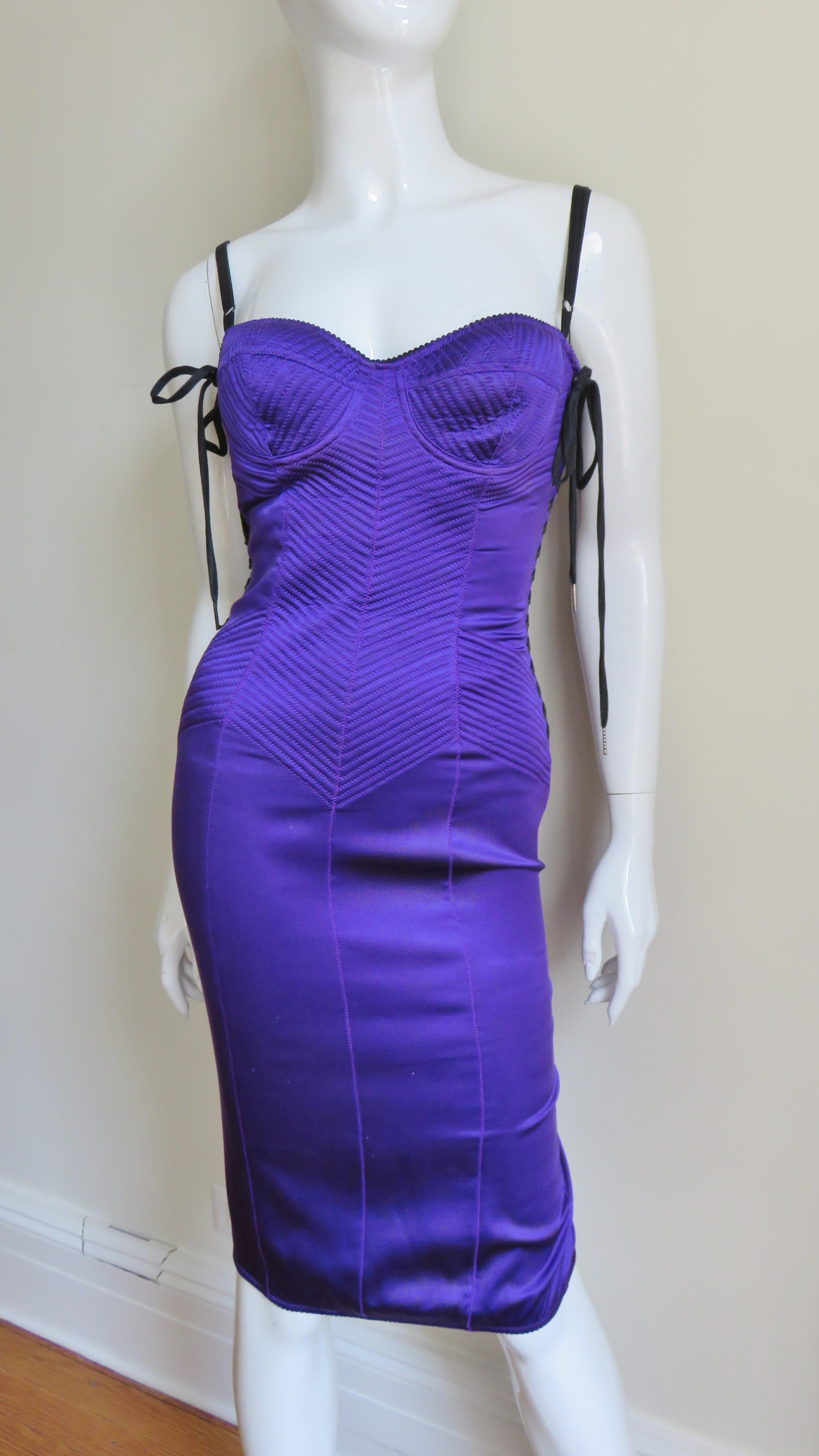 A beautiful purple stretch silk dress from Dolce & Gabbana.   It has figure enhancing rows of stitching at angles throughout the torso. The sides have functional lacing from underarms down through the hips.  The under wire bodice is top stitched and