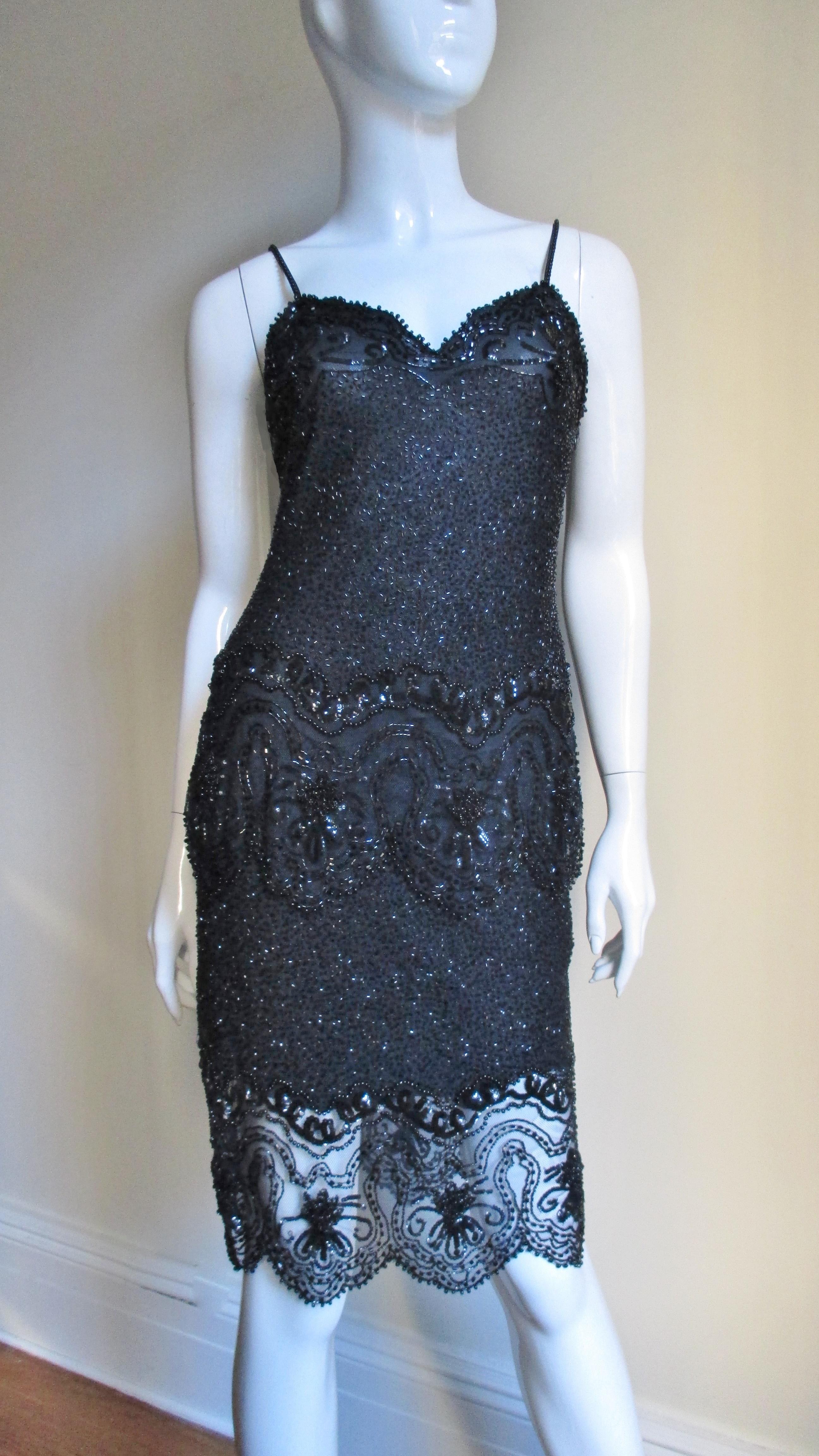 A gorgeous 2 piece set skirt and camisole set from Coty award winner designer Fabrice's Couture collection in black semi sheer silk covered in glass beads and with sequin accents. The top has spaghetti straps, a scallop hem and is covered in black