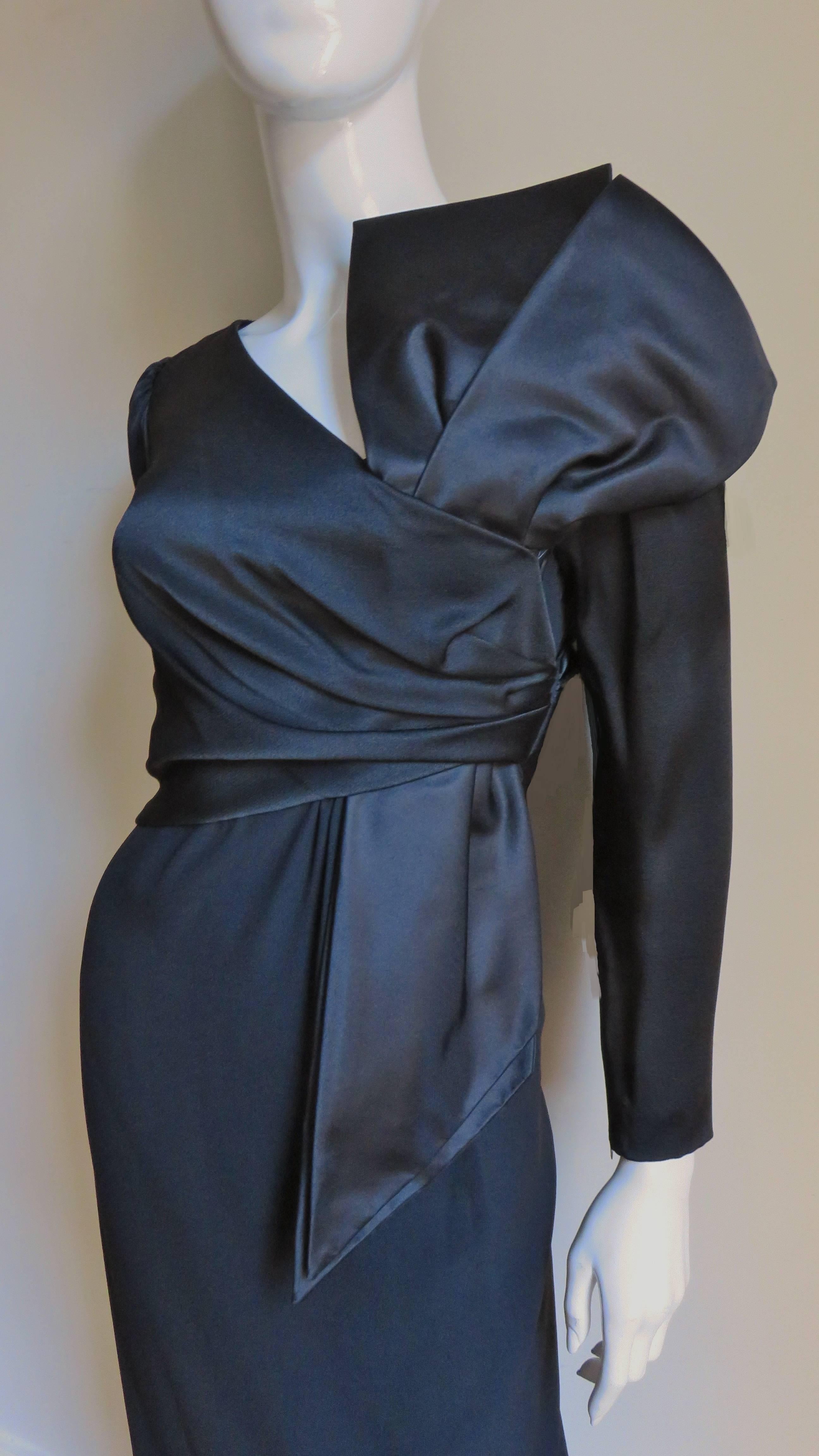 A fabulous dramatic black silk and jersey dress by Bill Blass.  It is semi fitted with long sleeve dress and a silk bodice wrapping at the front giving forming a large vertical bow off center front.  The sleeves are gathered at the shoulders and