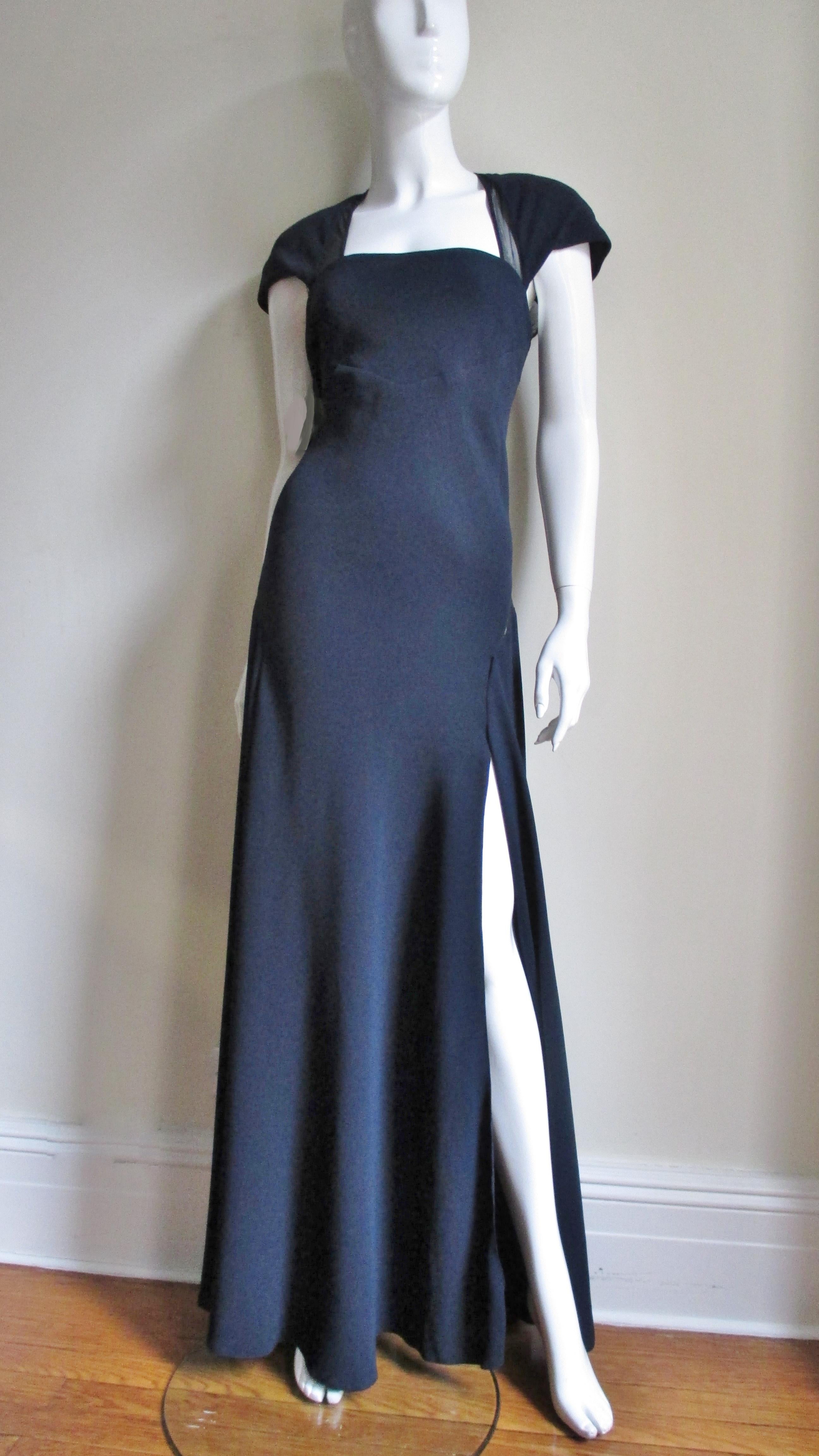 A beautiful navy blue silk gown with strategically placed sheer panels along the sides of the square neckline and back. Jackie Rogers known for her simple shapes and focus on fit has been designing in New York since the 1960's for actresses and