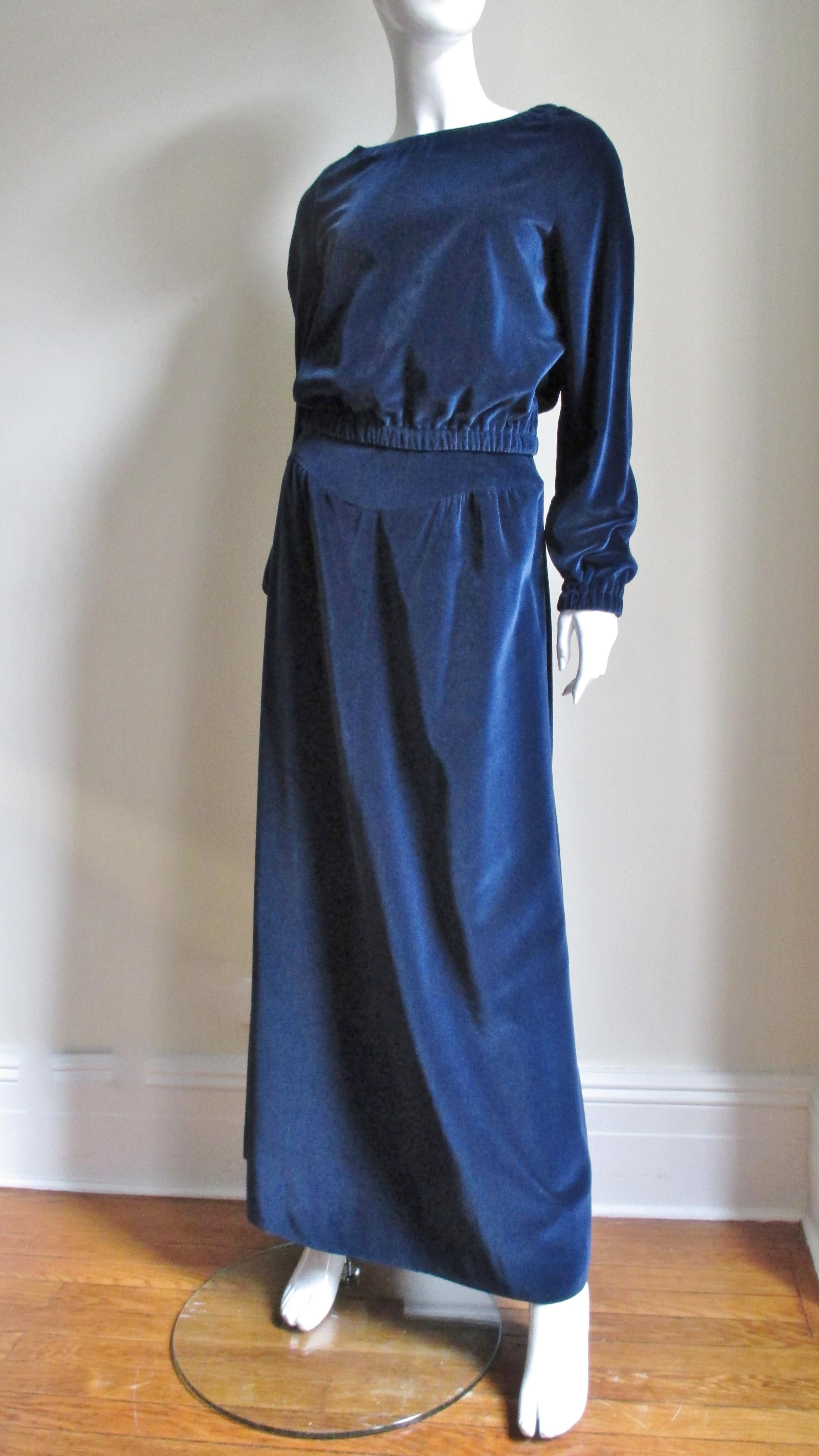 A fabulous 2 piece blue velvet skirt and top set from Courreges.  The maxi skirt is gathered onto a front and back yoke and flares subtly to the hem. The bateau neck blouson top has stretch at raglan sleeve wrists, waist and neckline and can be worn